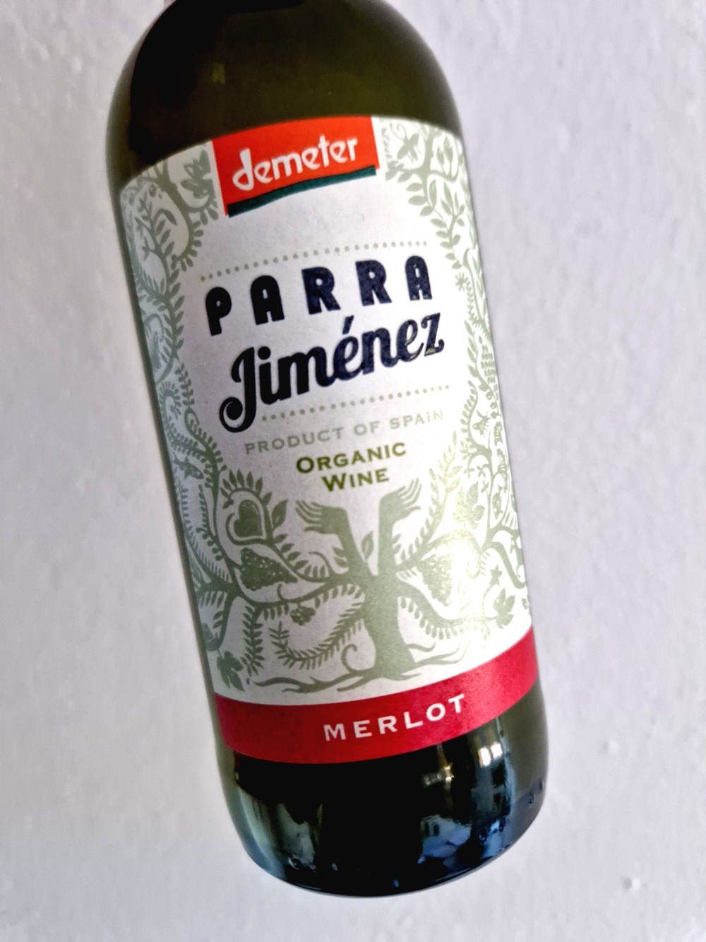 Eine Flasche Rotwein vor weißer Tapete