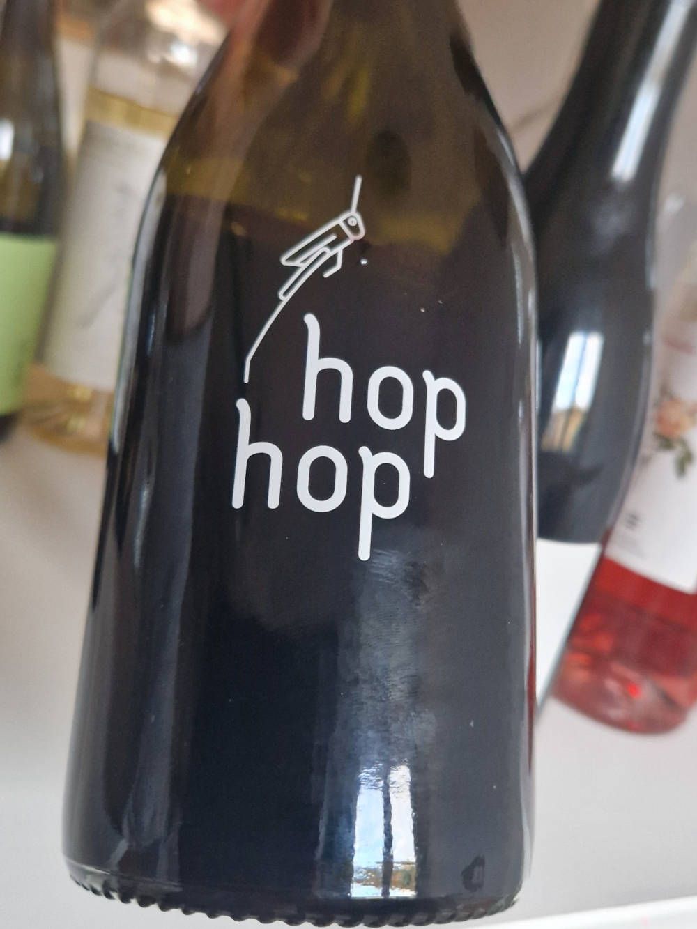 eine Flasche Wein mit einem Grashüpfer