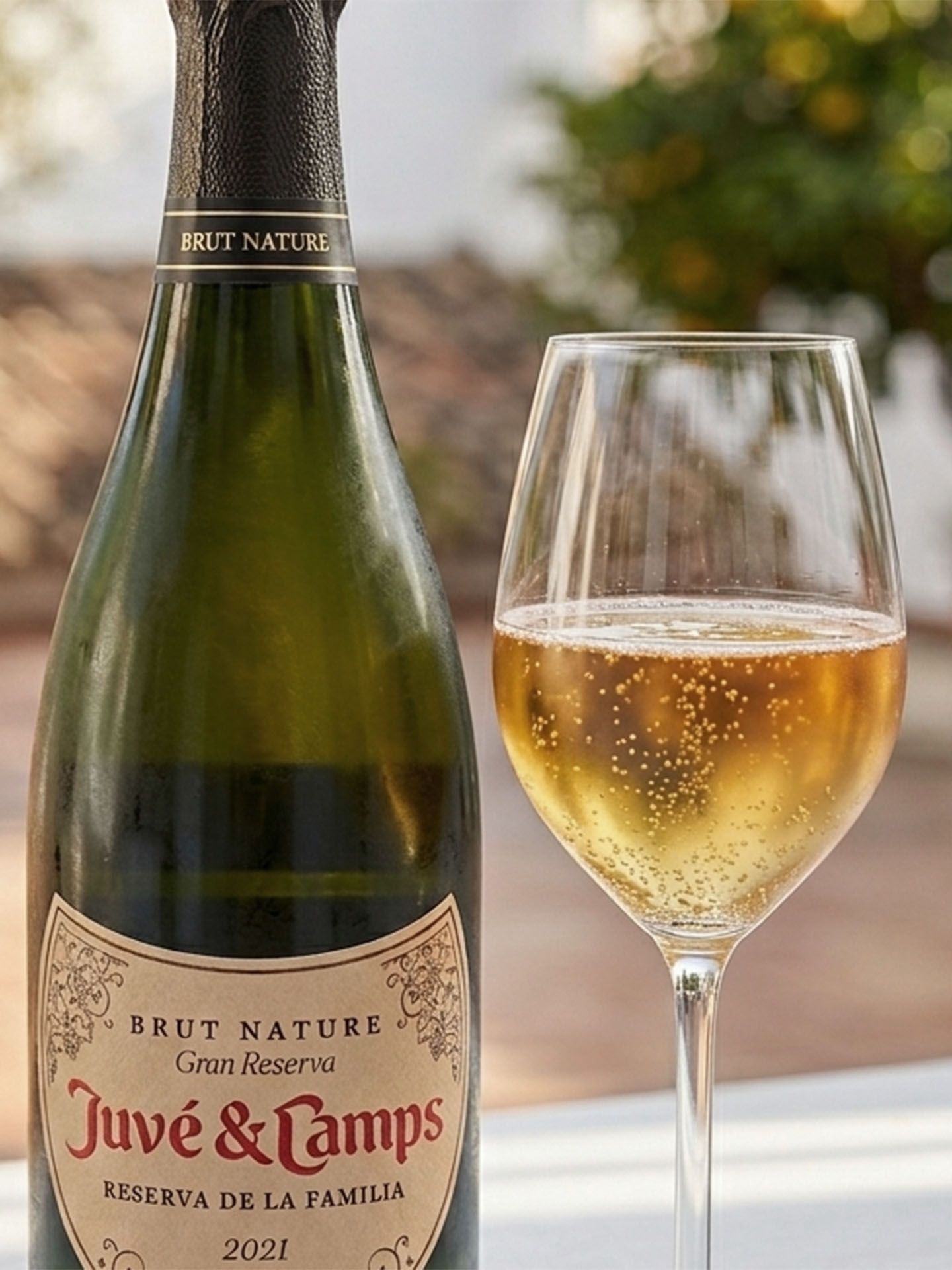 Flasche Juve Camps Gran Reserva 2021 auf Tisch mit einem Glas