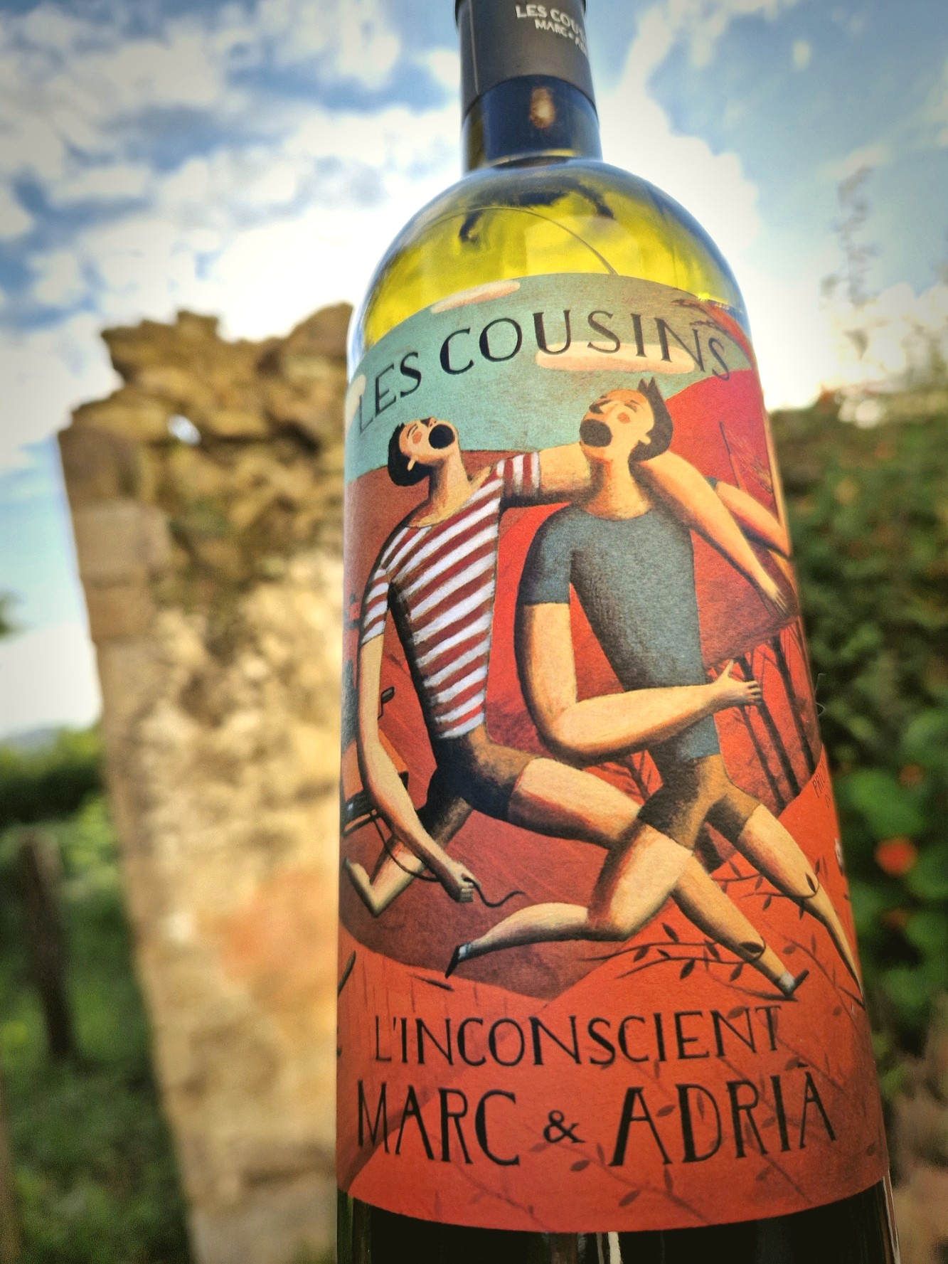 Eine Flasche Rotwein vor einer Ruine