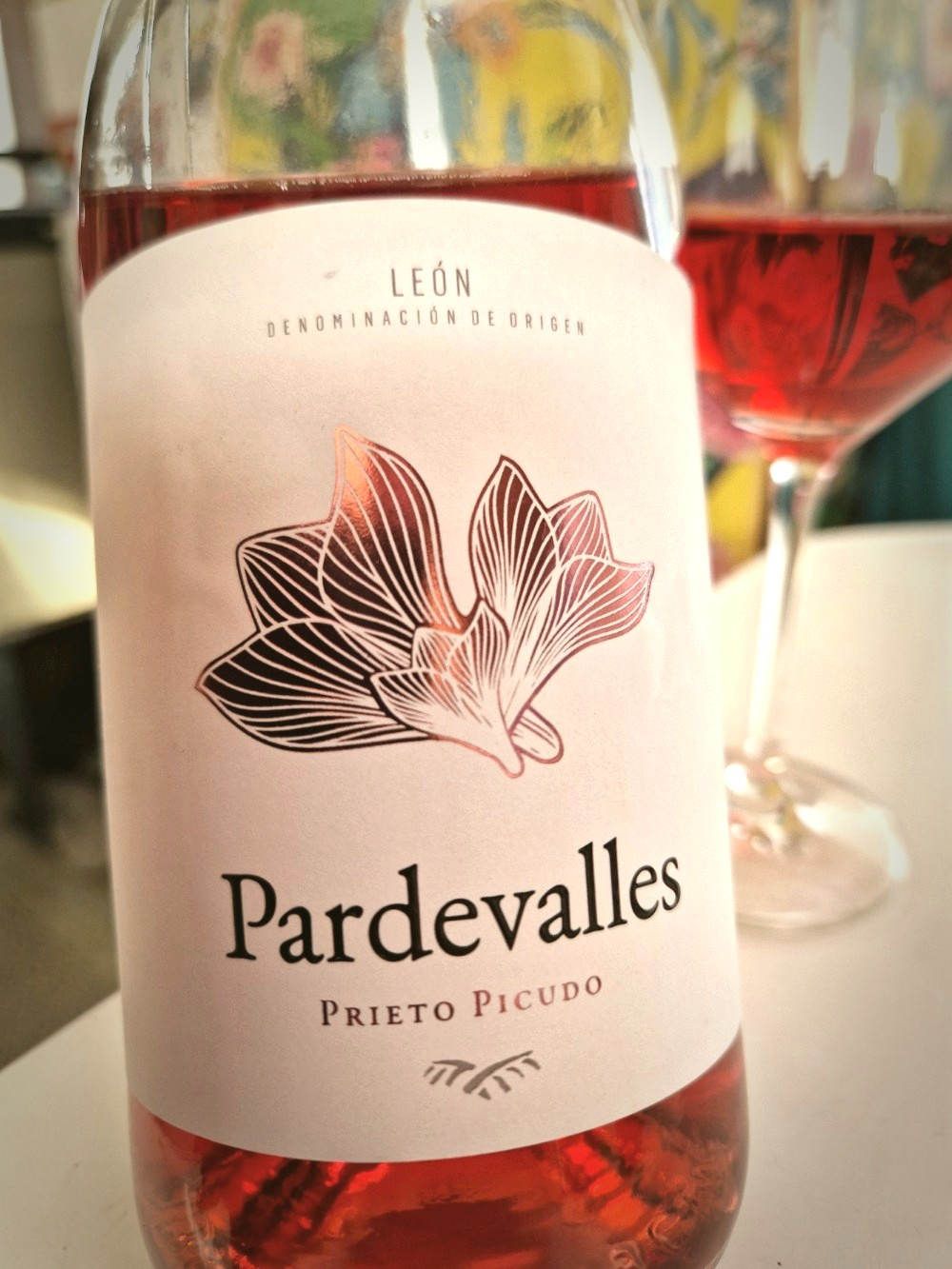 Eine angebroche Flasche Rosé und dahinter ein Glas