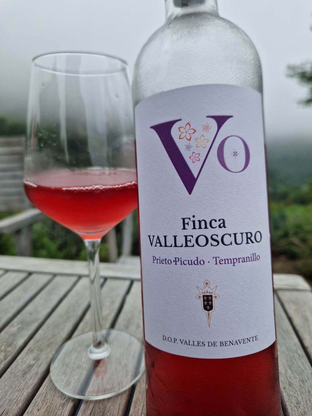 Eine Flasche Roséwein mit einem Glas auf einem Tisch