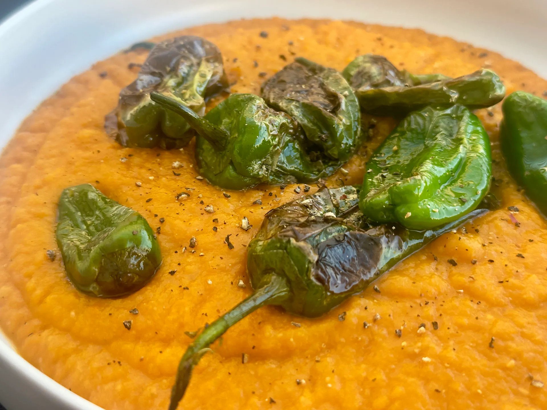 Süßkartoffelsuppe Rezept mit gebratenen Pimientos de Padrón serviert