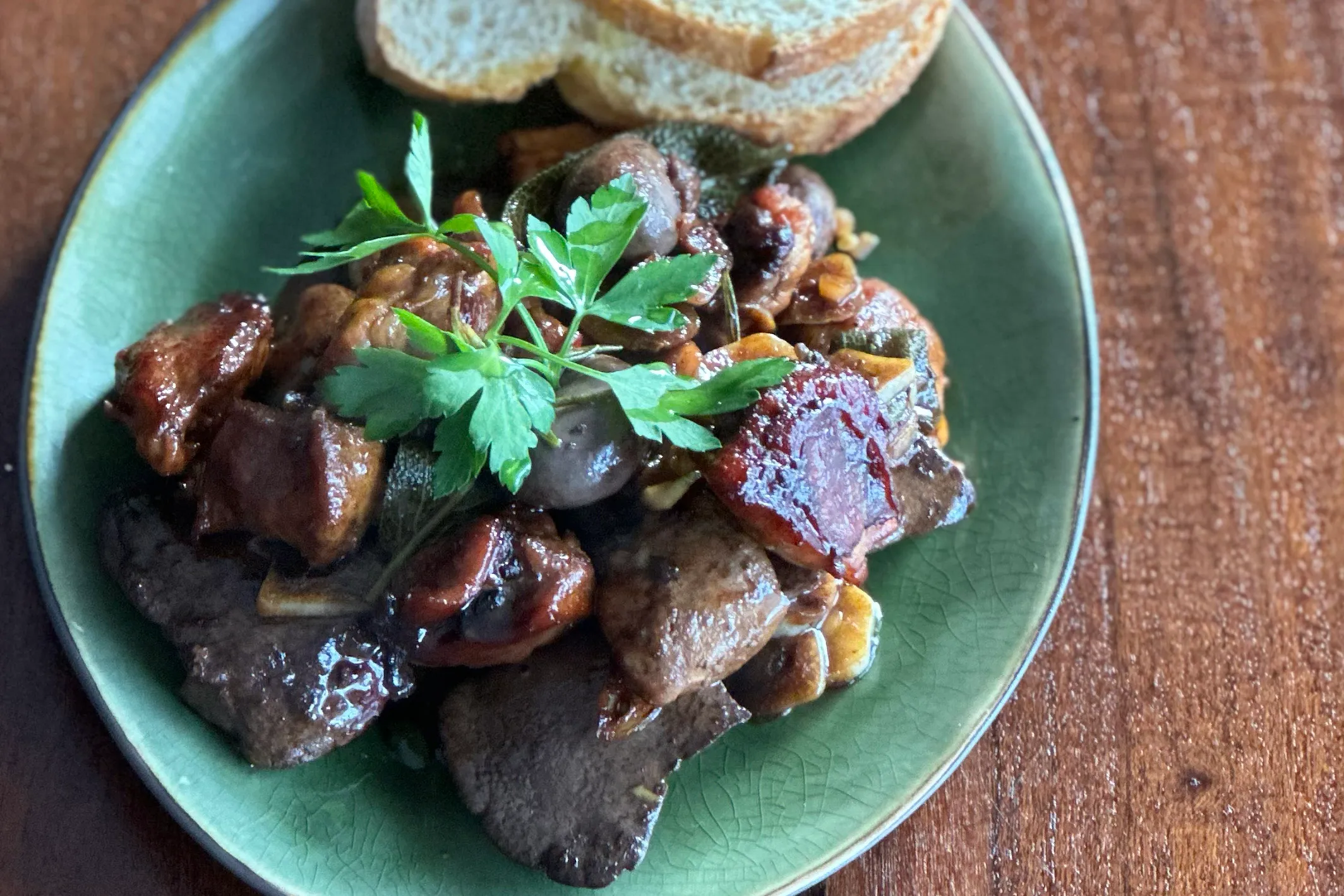 Kaninchen in Pedro Ximenez Sauce angerichtet auf einem Teller mit Brot