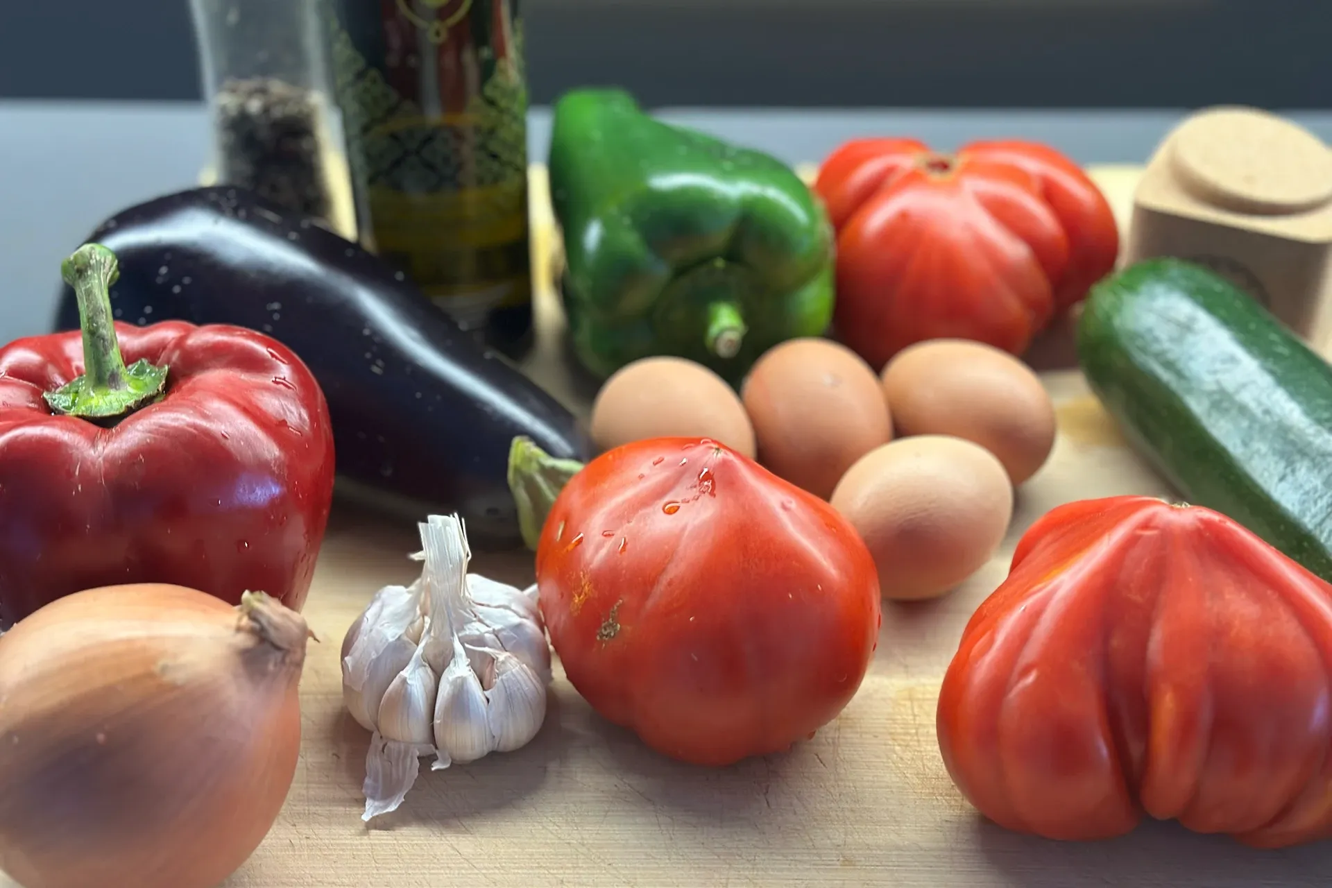 Zwiebeln, Knoblauch, Paprika, Aubergine, Eier und eine Flasche Olivenöl