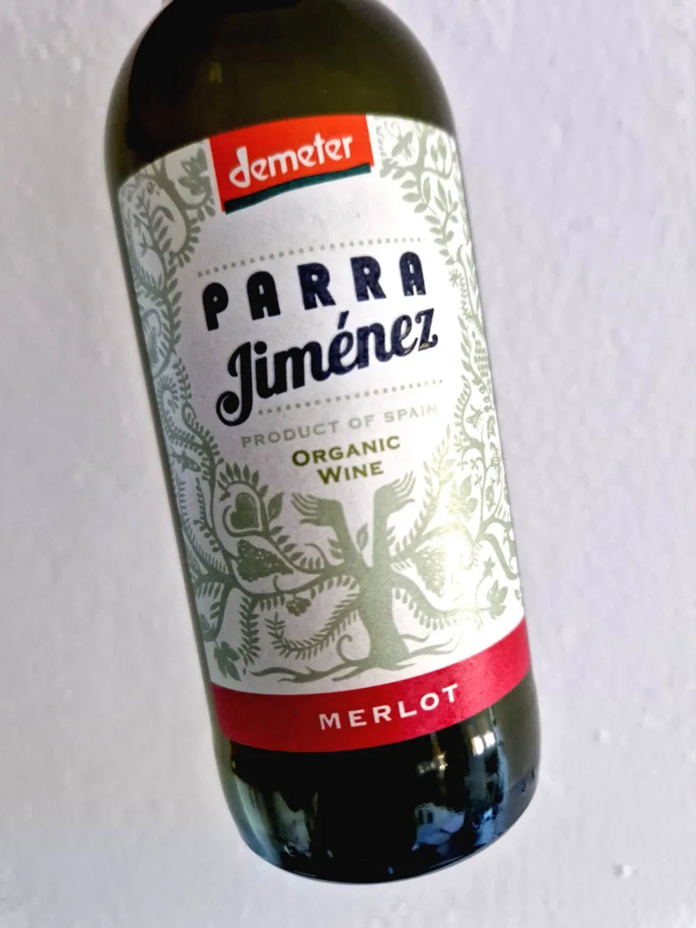 Eine Flasche Rotwein vor weißer Tapete