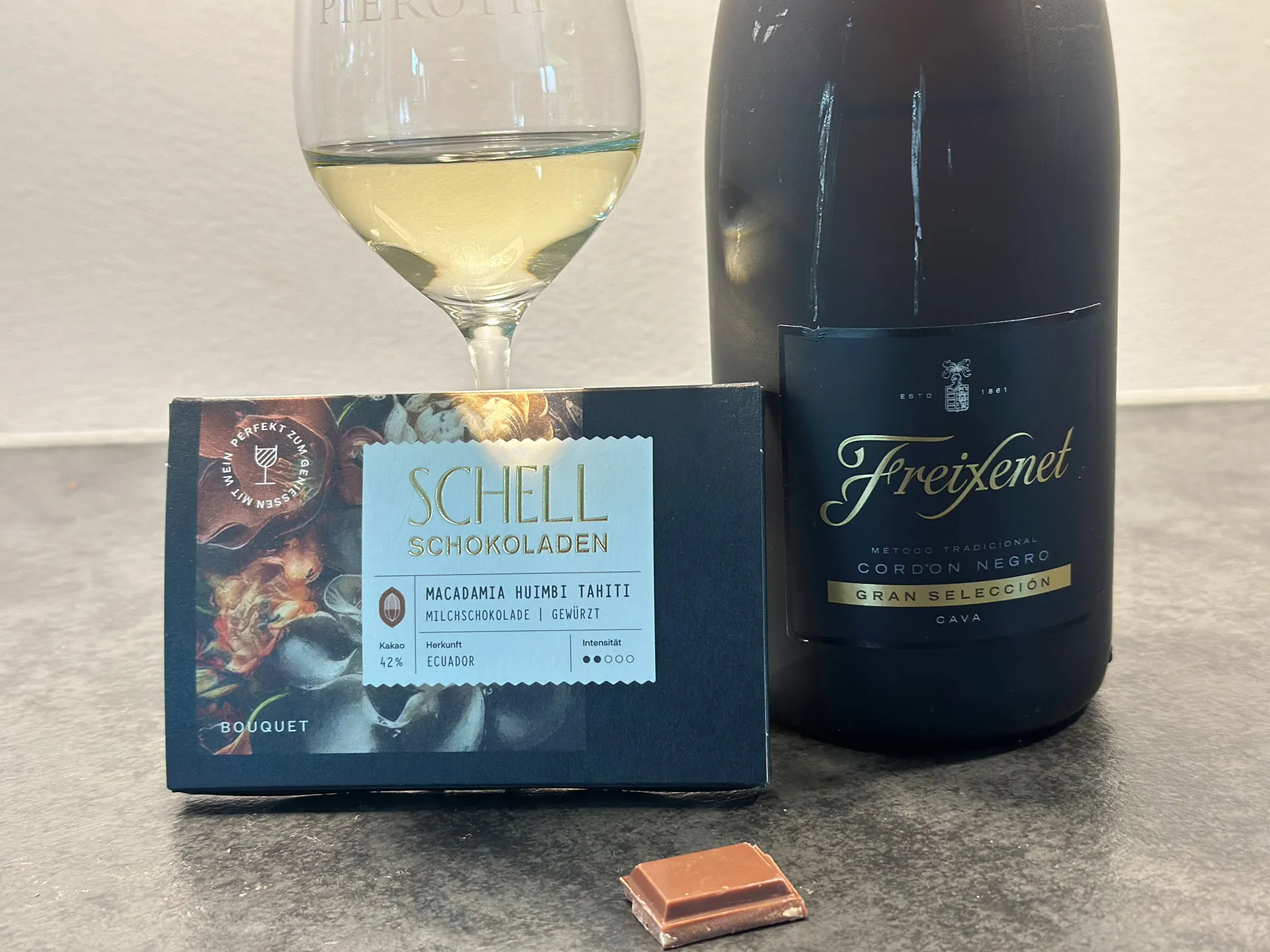 Glas mit Sekt und Cava Flasche mit Schokolade auf Tisch