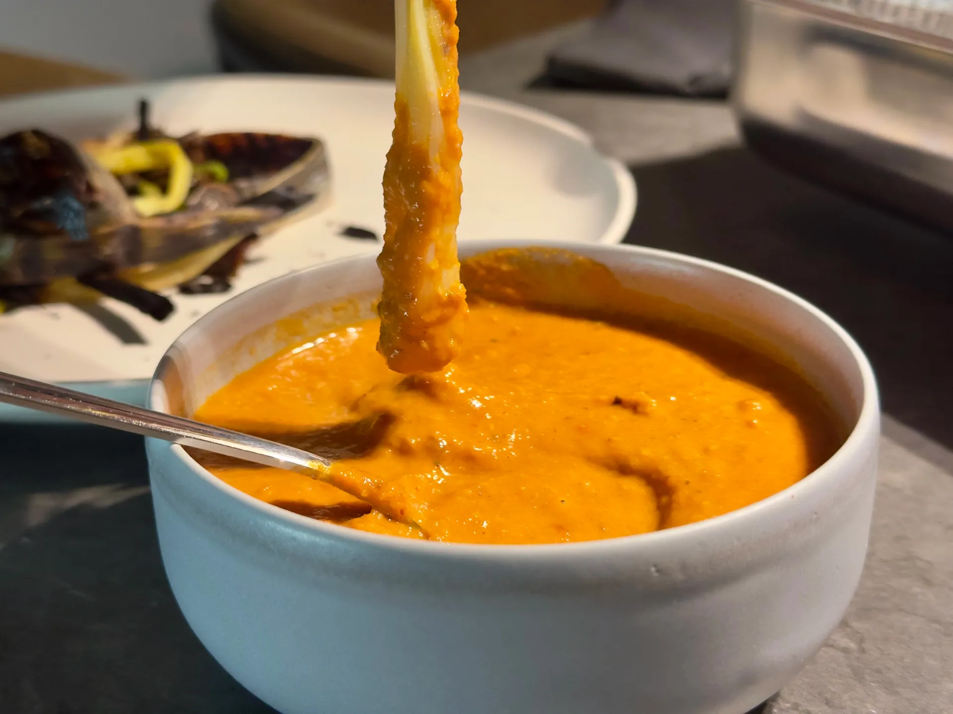 Calçots werden in Romesco Sauce getunkt