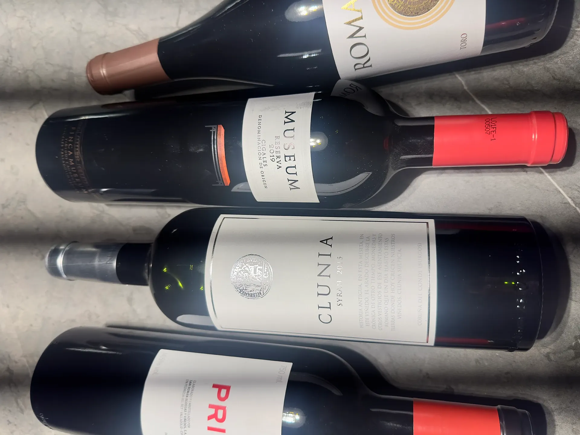 vier Flaschen spanische Rotweine liegen auf einem Tisch