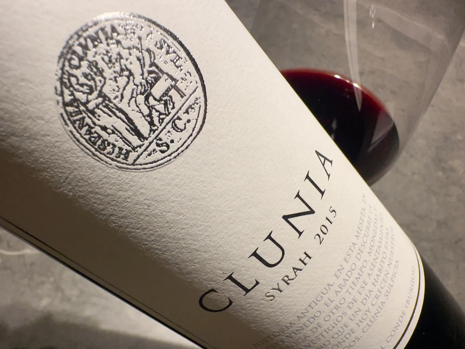 Weinflaschenetikett mit Clunia Syrah und Glas