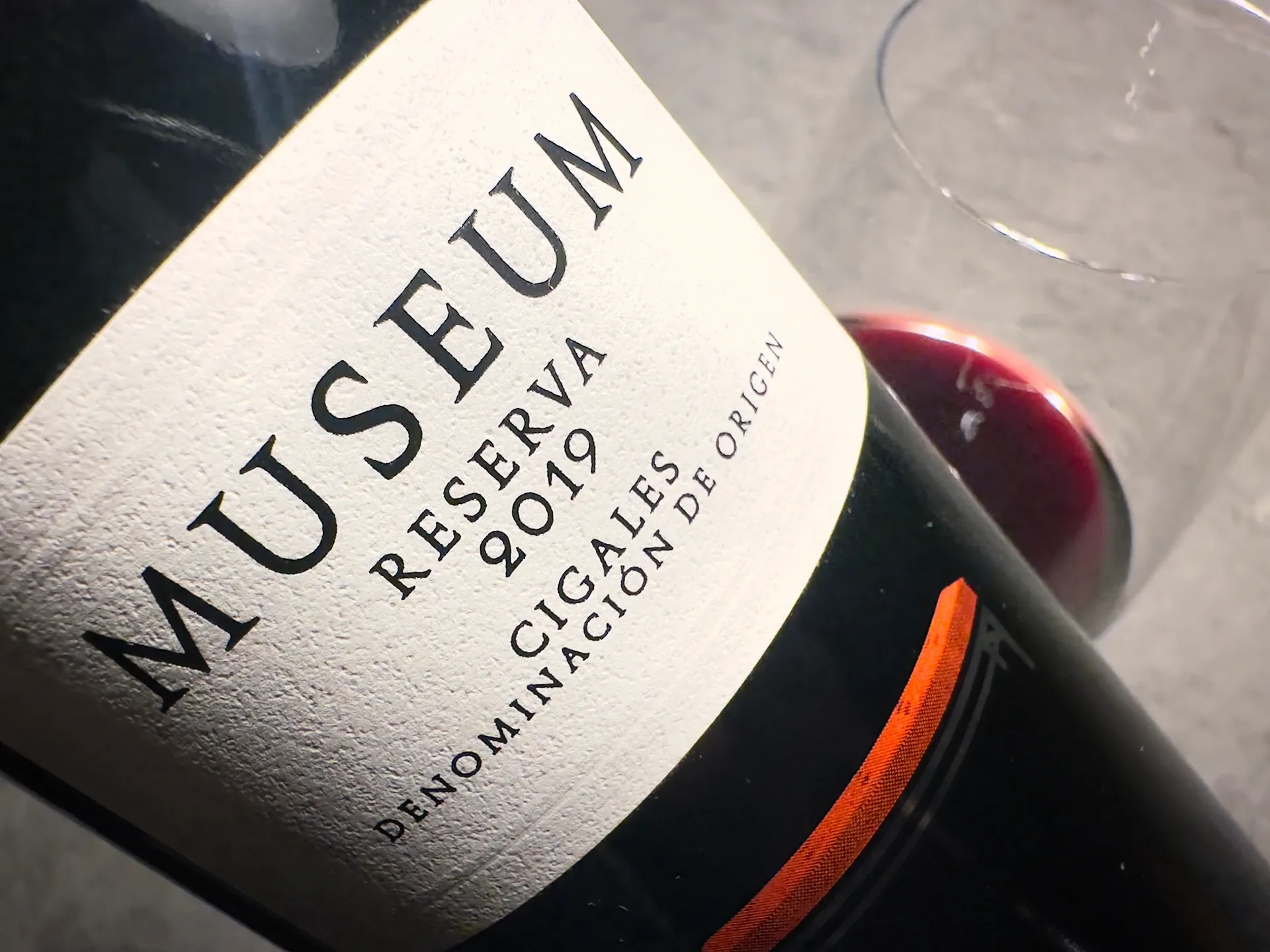 Weinflasche mit einem kleinen Etikett und der Aufschrift Museum Reserva und Glas