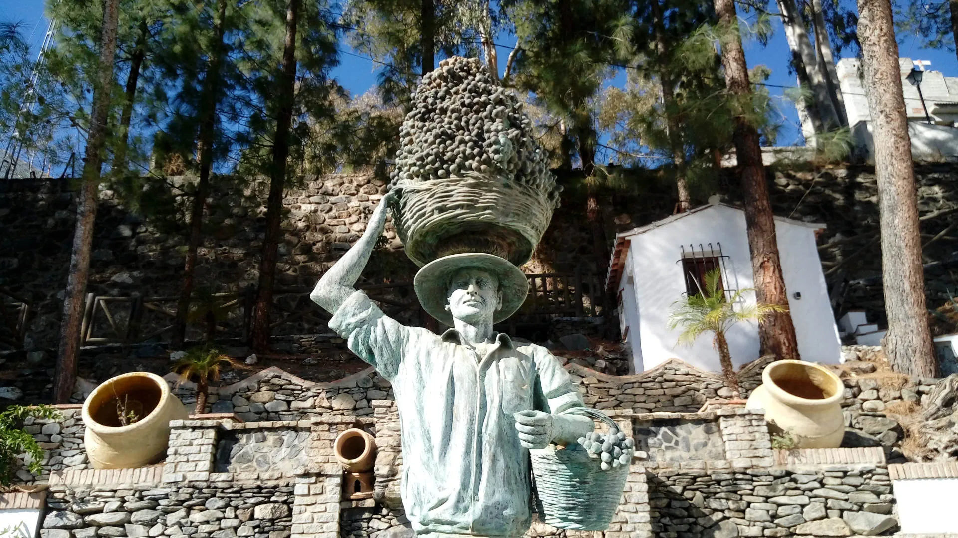 Eine Statue, die einen Korb mit Weintrauben auf dem Kopf trägt
