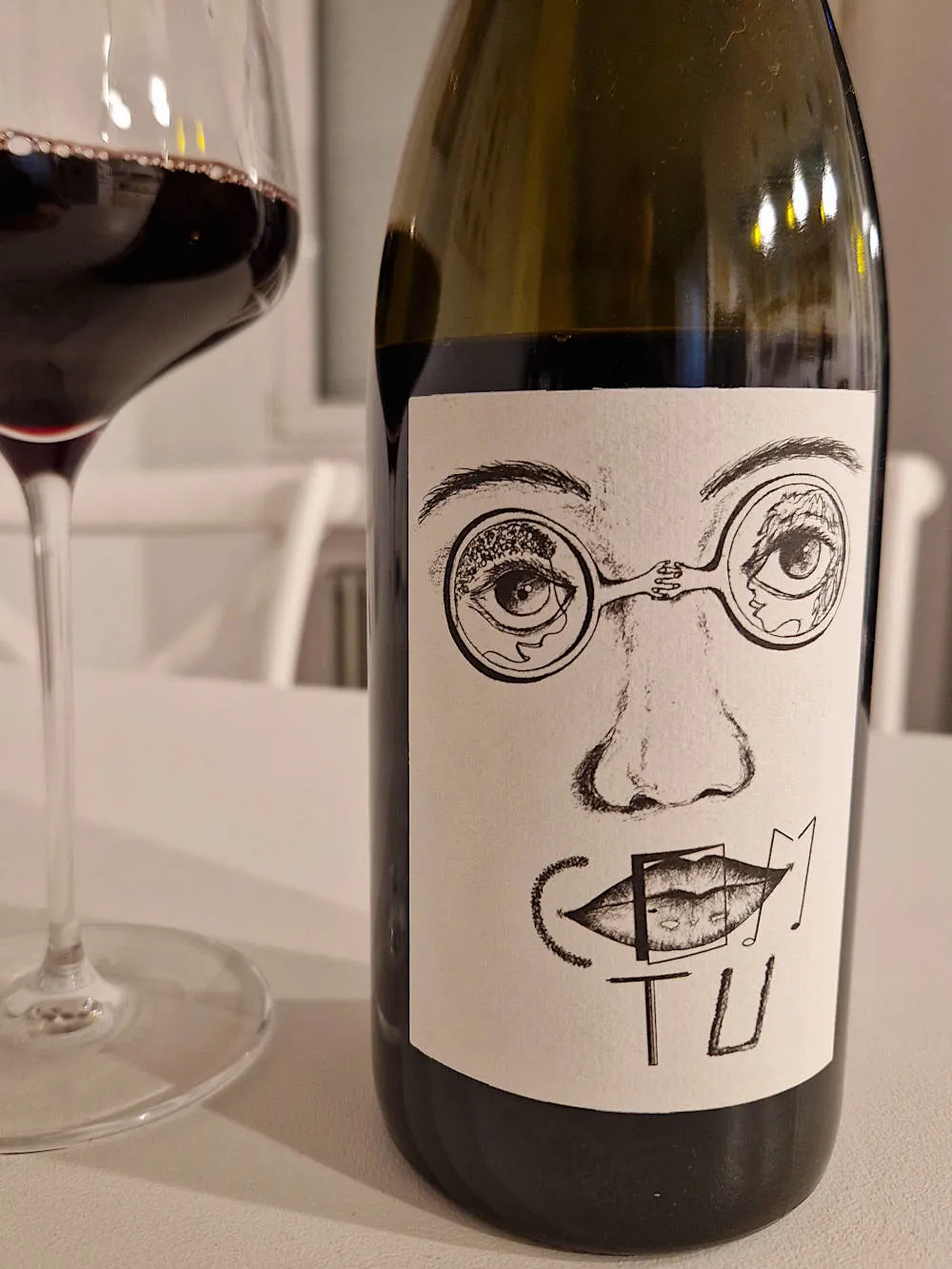 eine ausgefallenes Weinetikett mit eienr Brille aus zwei Armen
