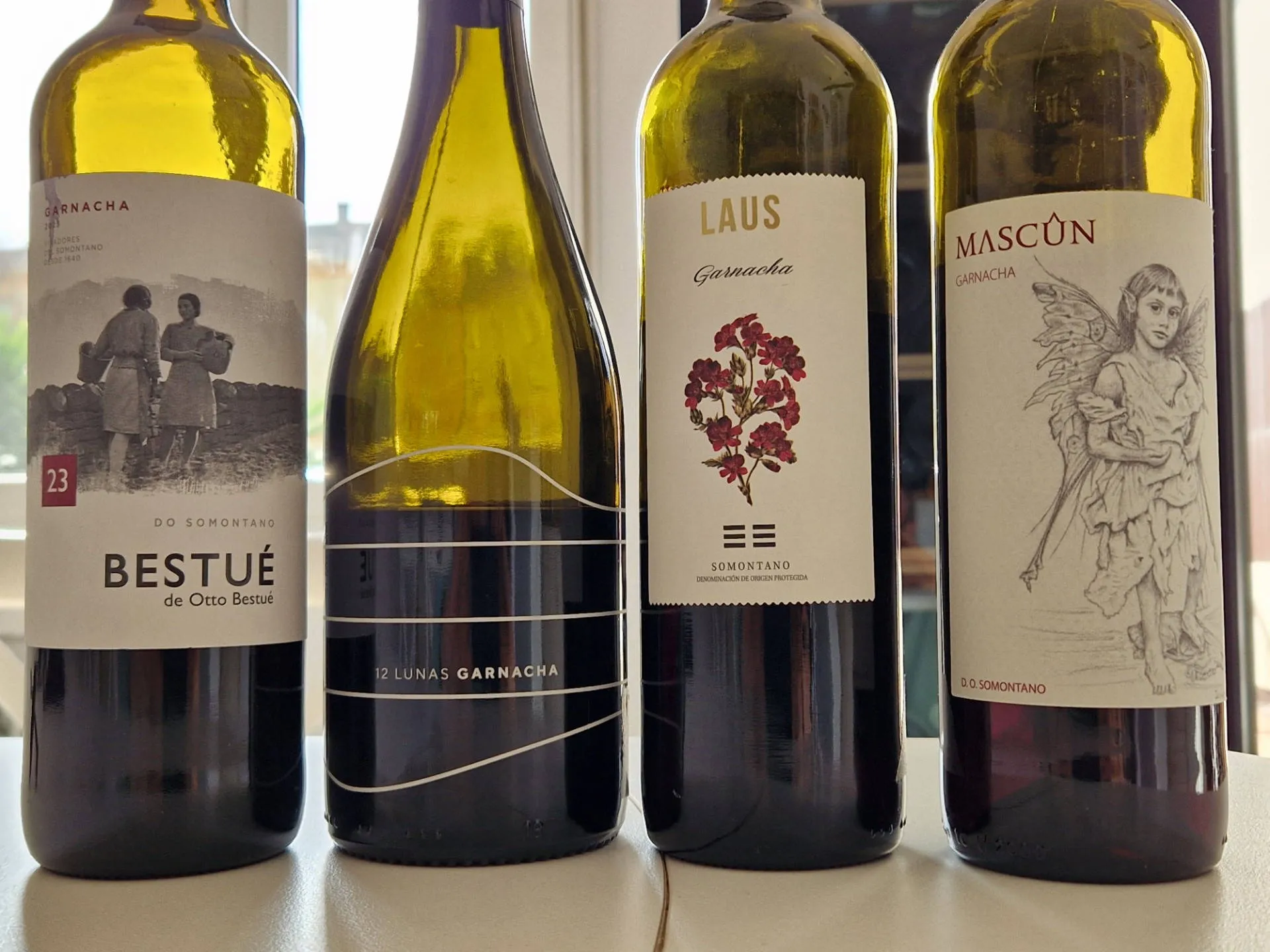 4 geöffnete Weine auf einem Tisch