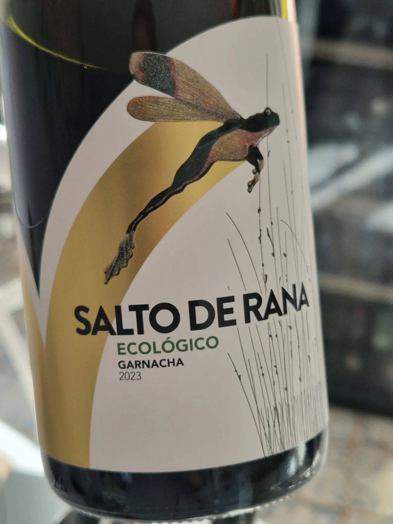 Eine Flasche Rotwein mit einem hüpfenden Frosch auf dem Etikett