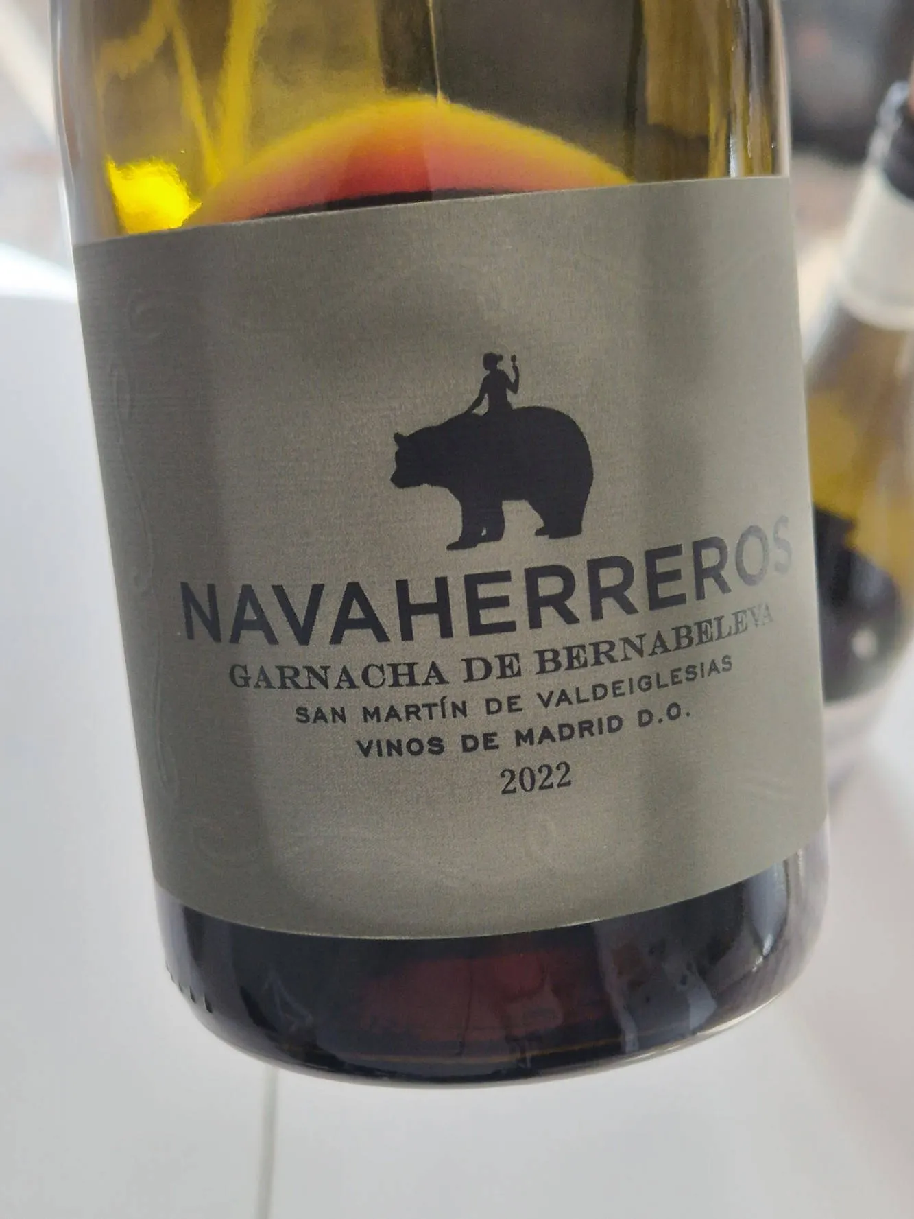 Eine Weinflasche, auf deren Etikett eine Frau auf einem Bären reitet.