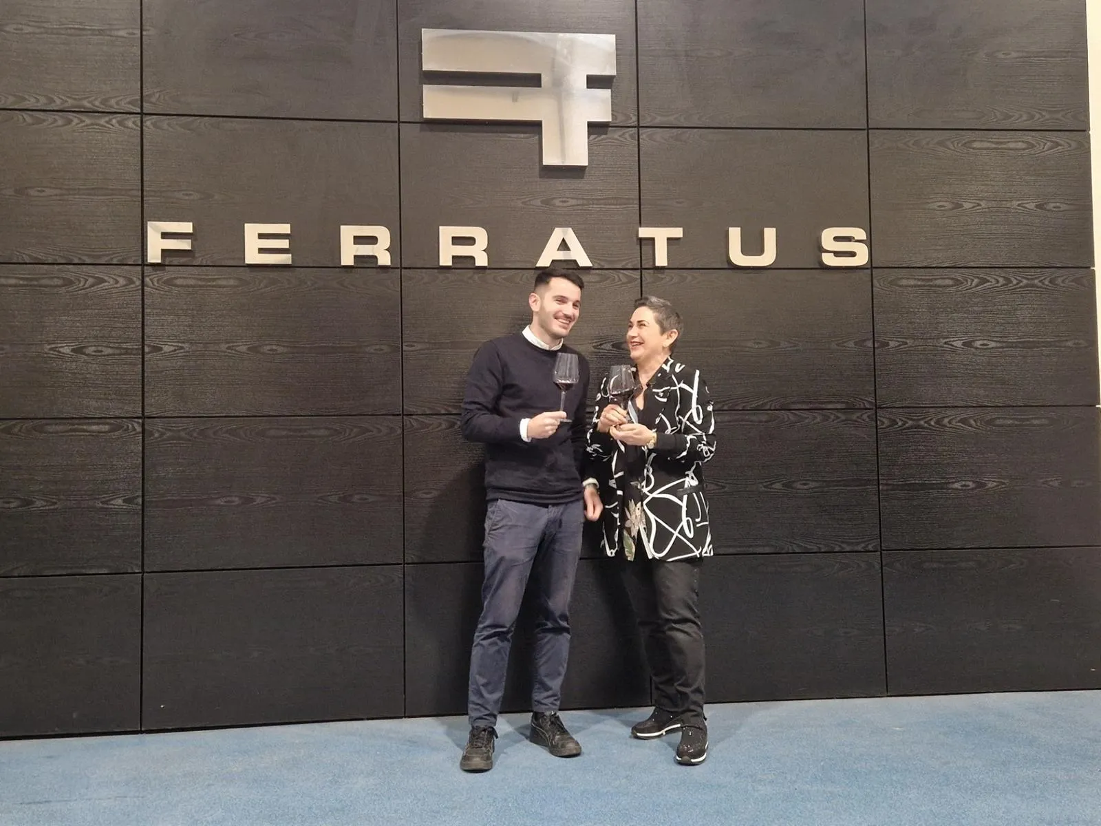 Zwei Personen unter einem großen Schriftzug eines Weinguts