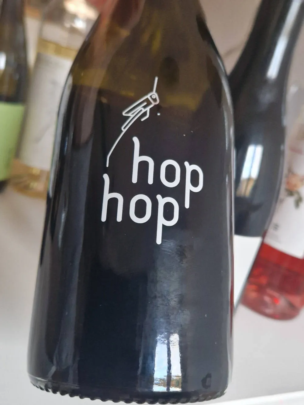 eine Flasche Wein mit einem Grashüpfer