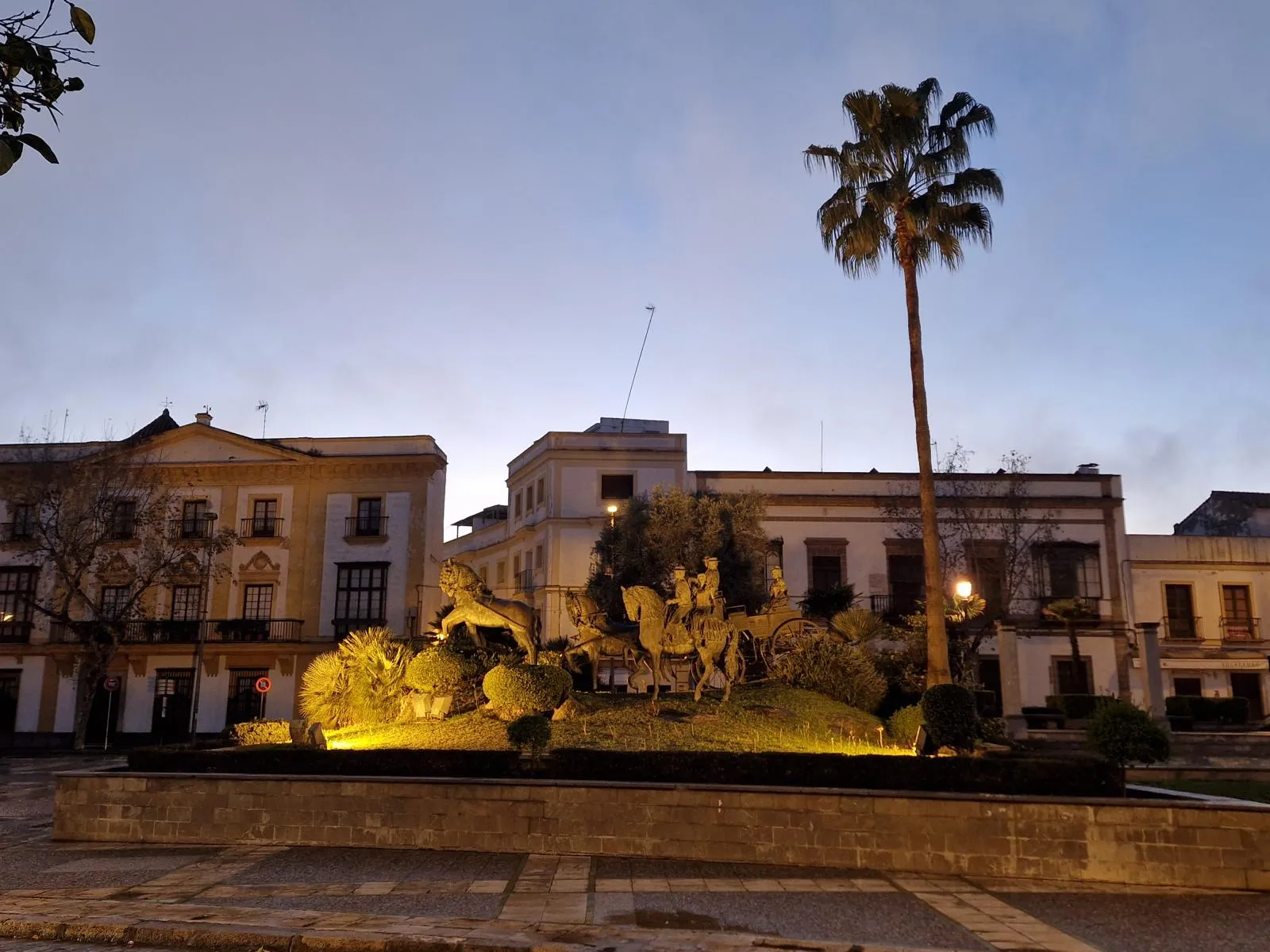 Eine Pferdestatue vor historischen Häusern in der Dämmerung