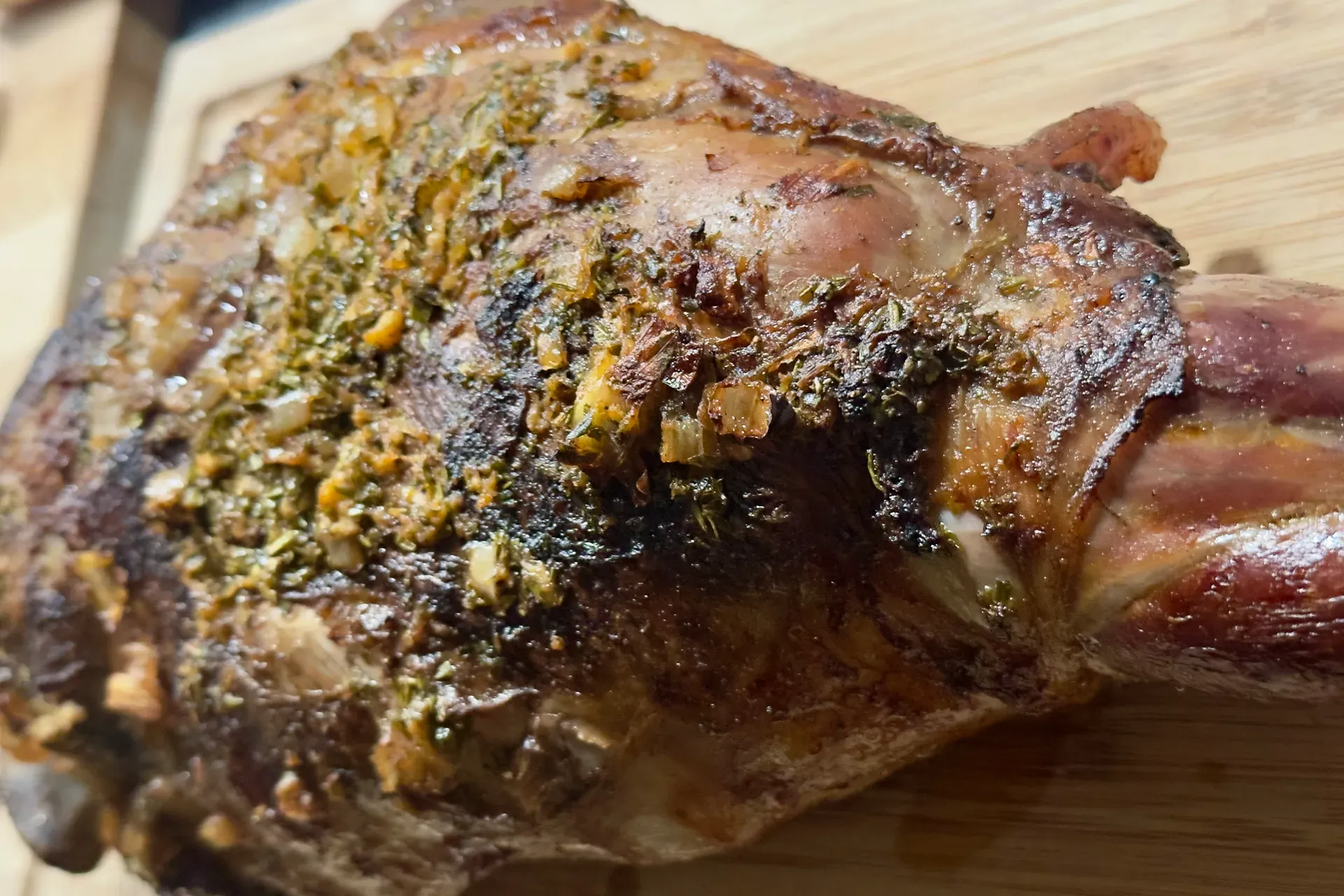 Eine fertige Lamm Haxe mit einer Kruste auf einem Holzbrett