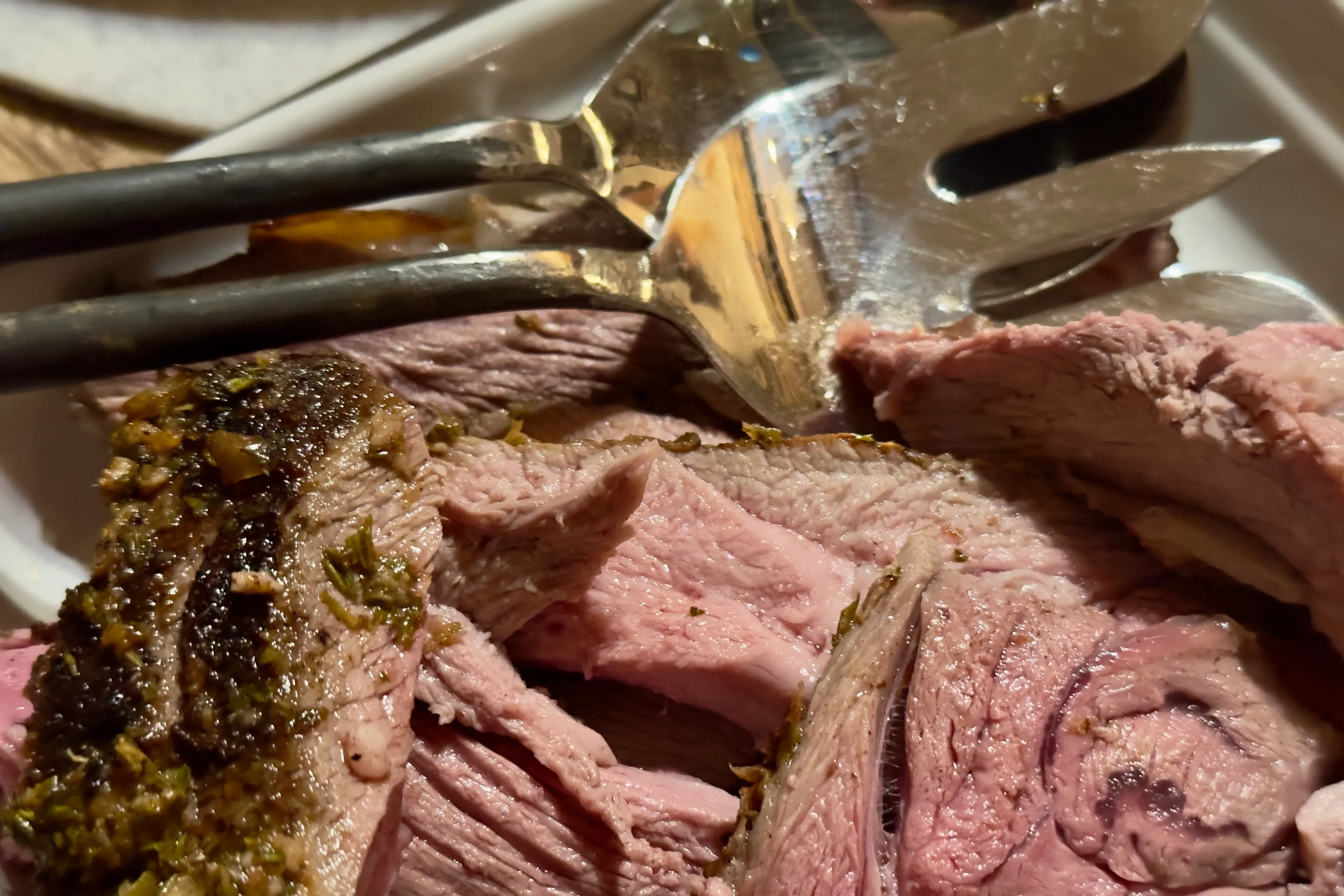 Braten Fleisch auf einem Teller mit Vorlegebesteck