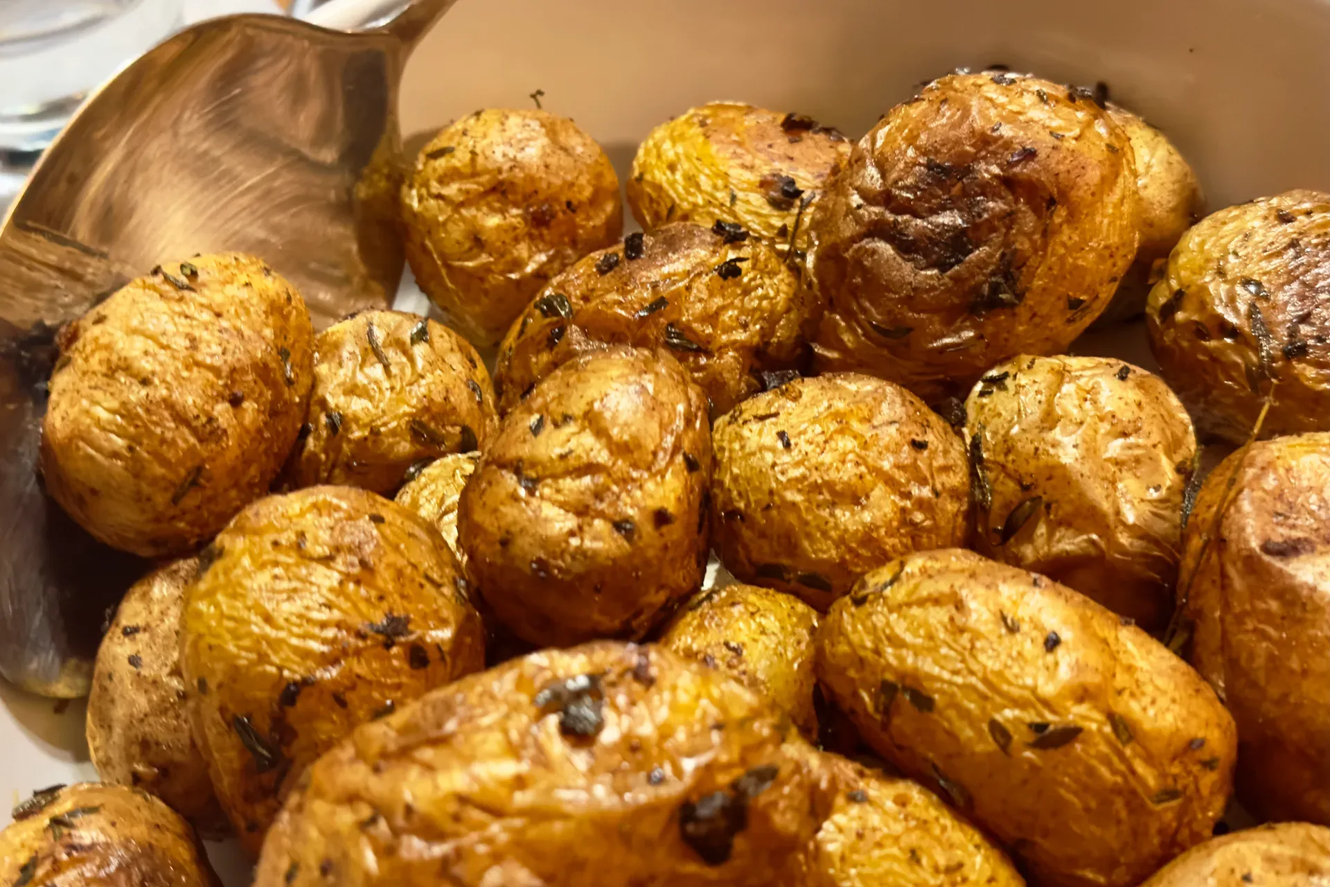 Ofenkartoffeln in einer Schale und Vorlegebesteck