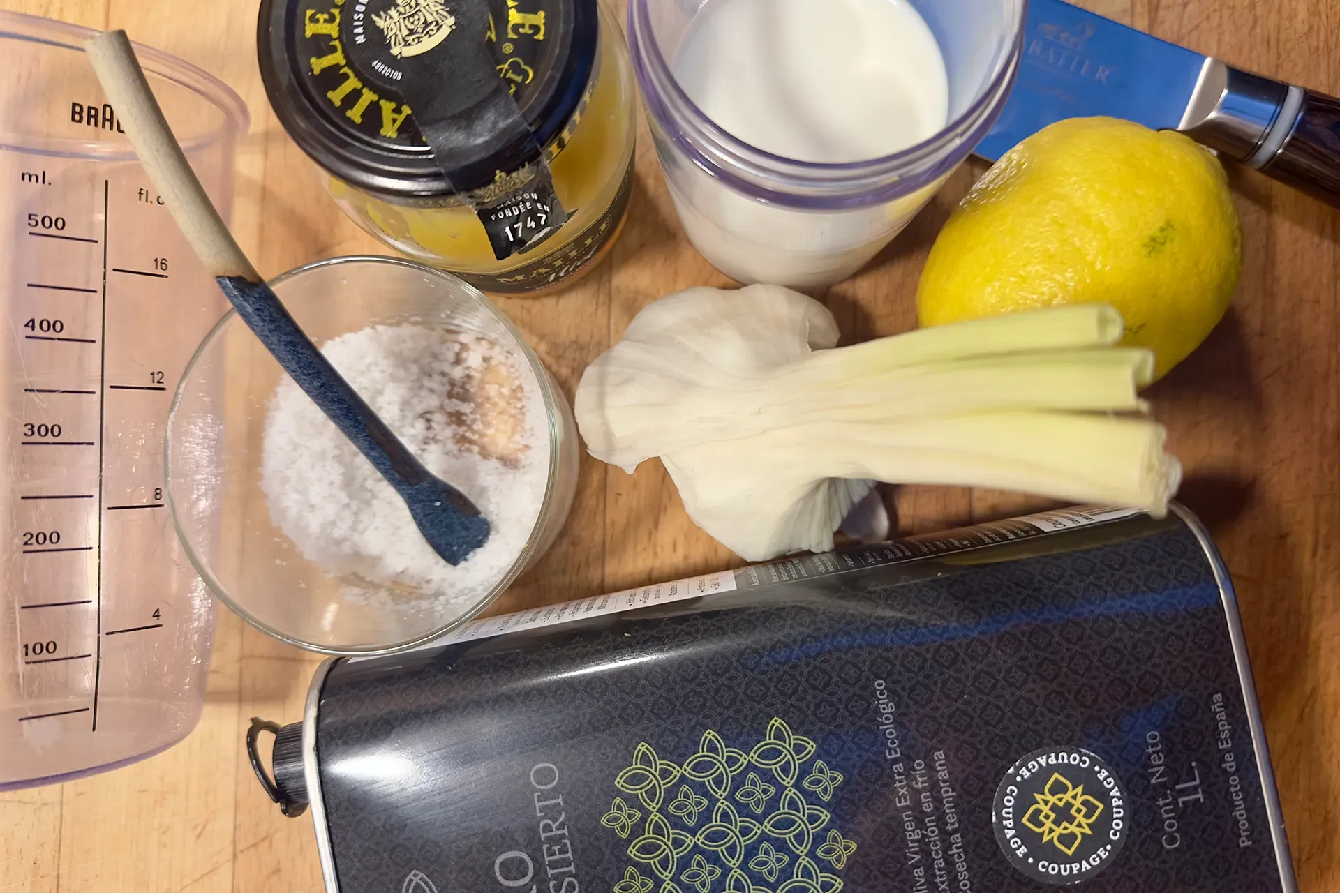 Auf einem Holzbrett liegen alle Zutaten für ein typisch spanisches Aioli