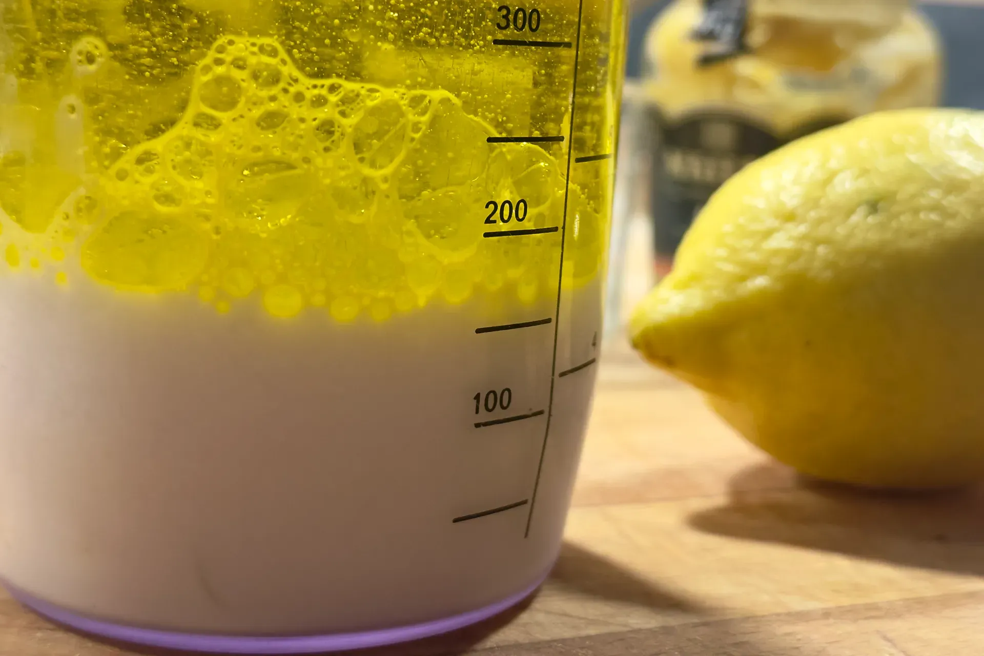 Ein Messbecher nebendran liegt eine Zitrone in der Messbecher ist Milch und Öl