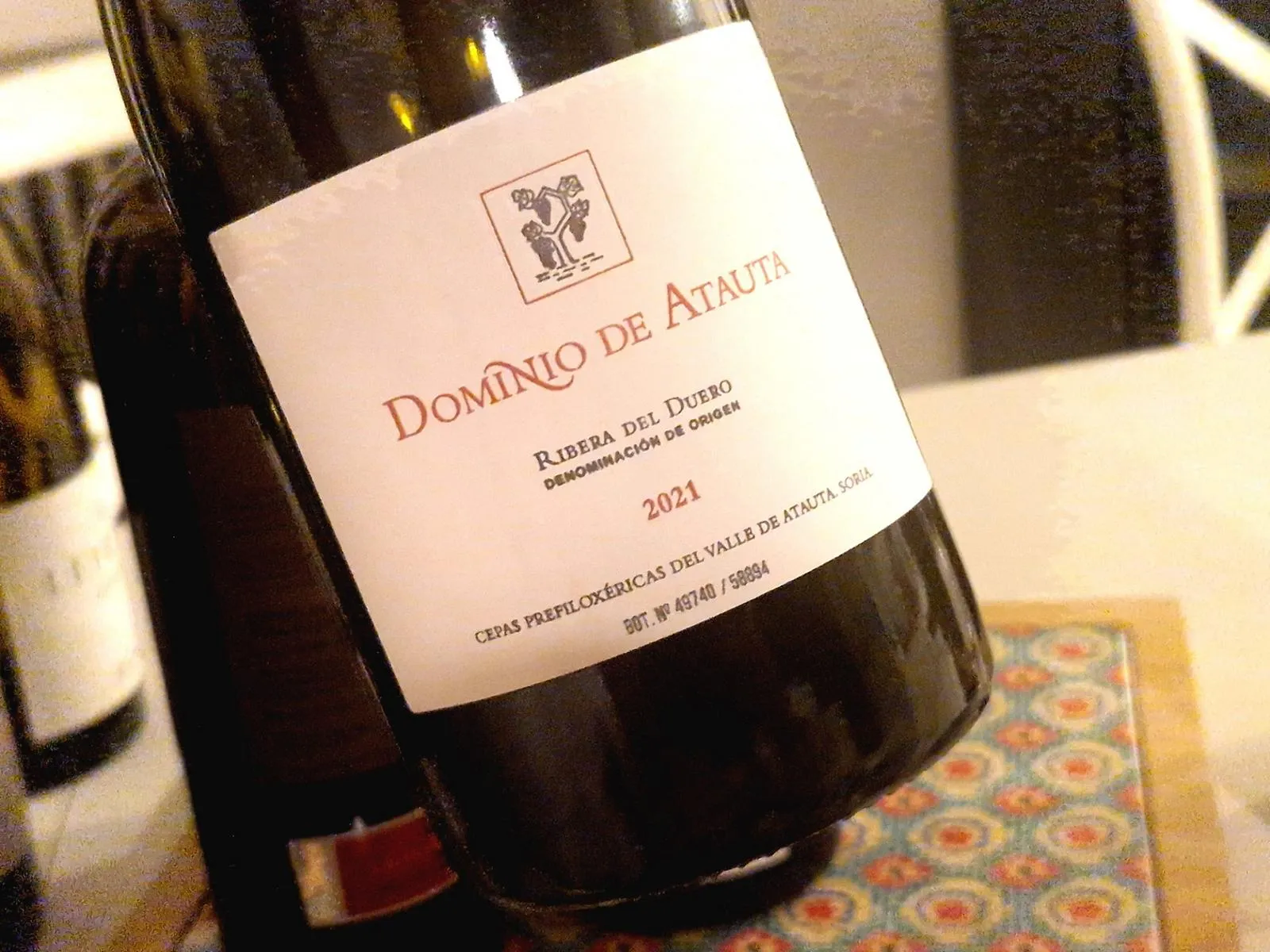 eine Flasche Wein vor einem Tisch mit weiteren Flaschen