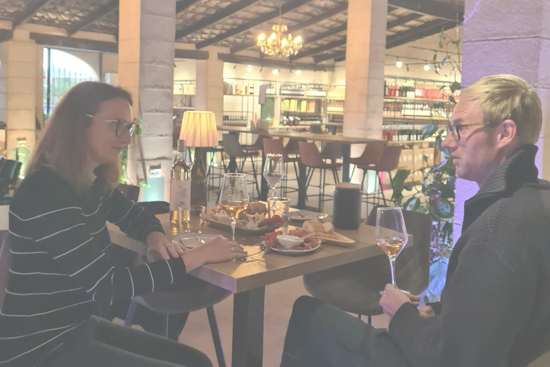 zwei Personen halten ein Interview, im Hintergrund eine Vinothek