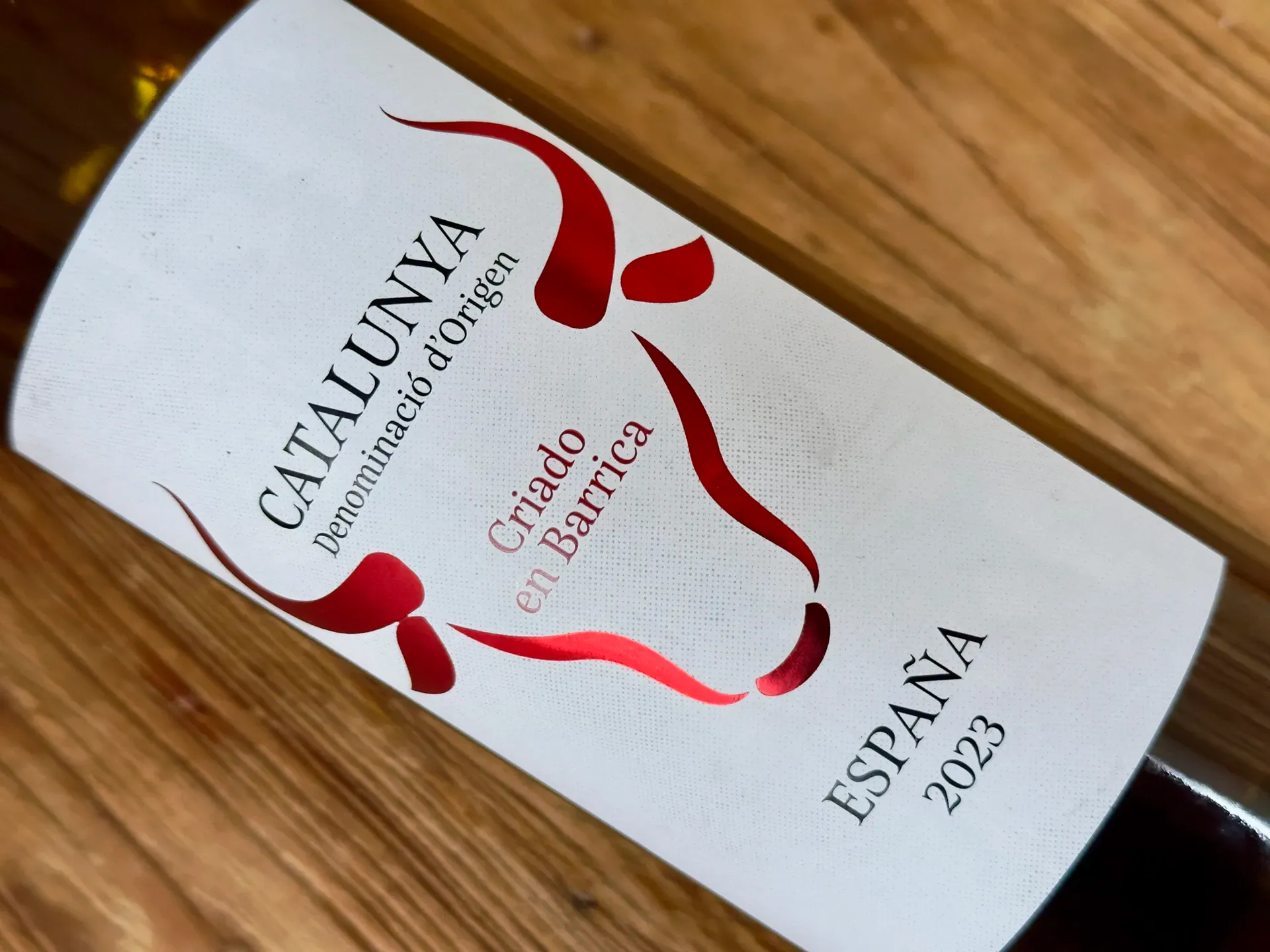 Weinfalsche mit Etikett Catalunya auf einem Holztisch