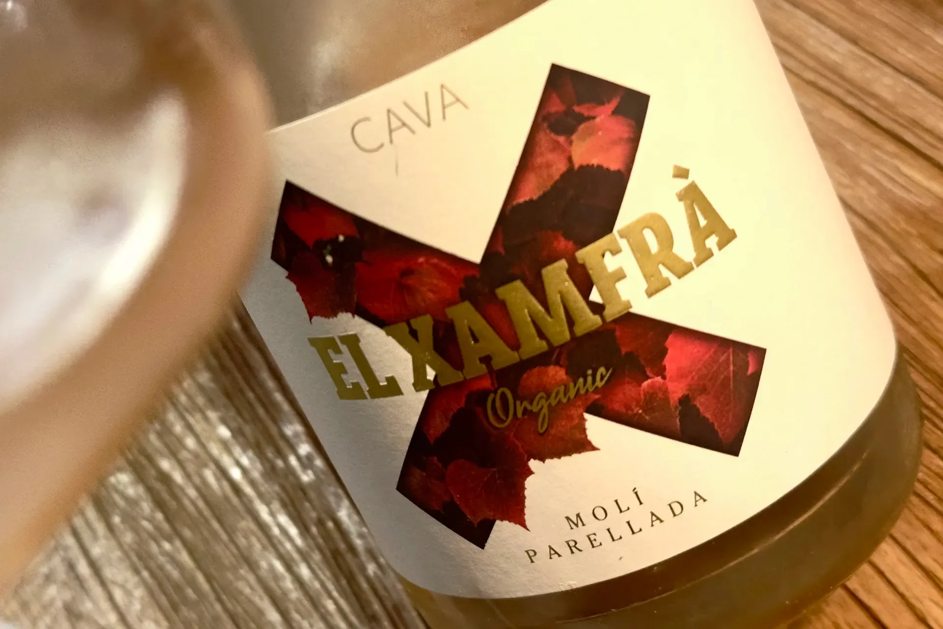 ein Glas mit Schaumwein und das Etikett von EL Xamfra Rose