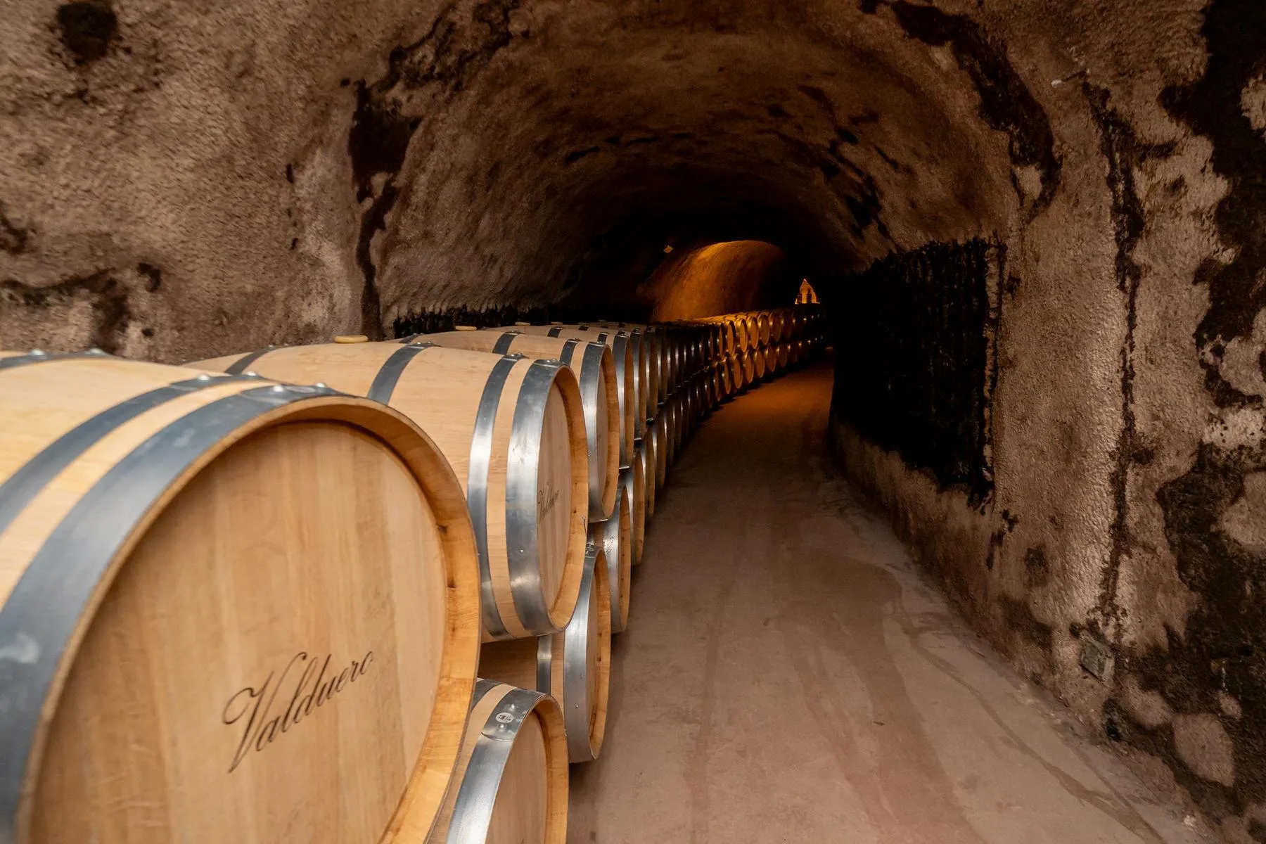 Schmaler Kellergang mit Weinfässern
