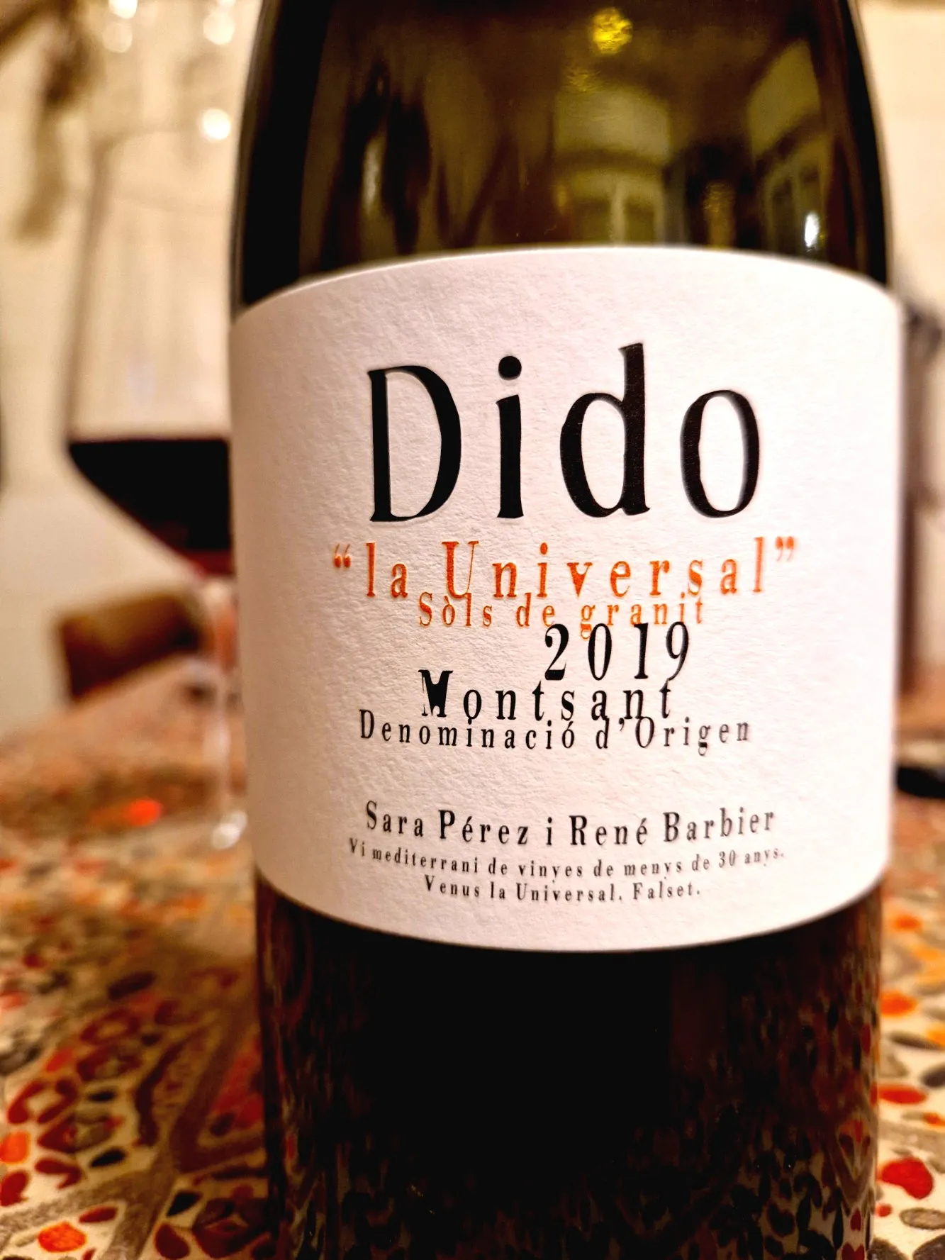 Eine Flasche Rotwein mit einem Glas auf einem Tisch