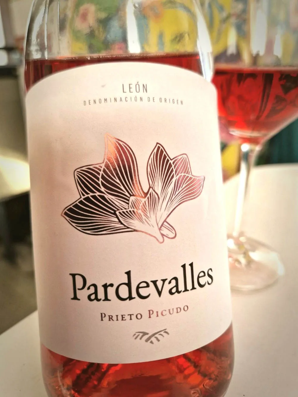 Eine angebroche Flasche Rosé und dahinter ein Glas