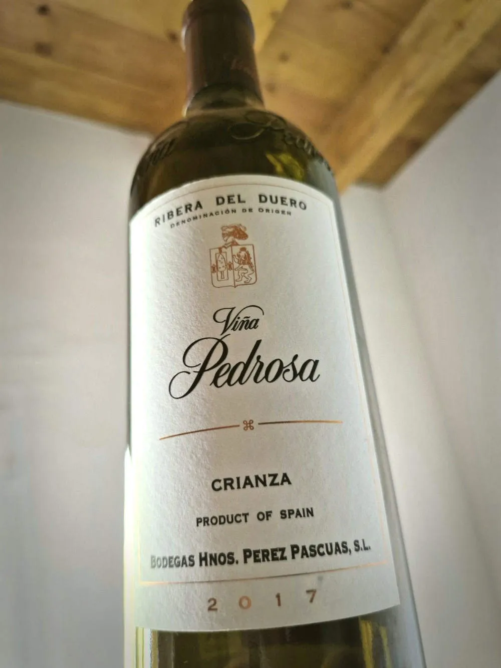 Eine Flasche Wein vor einer weißen Wand