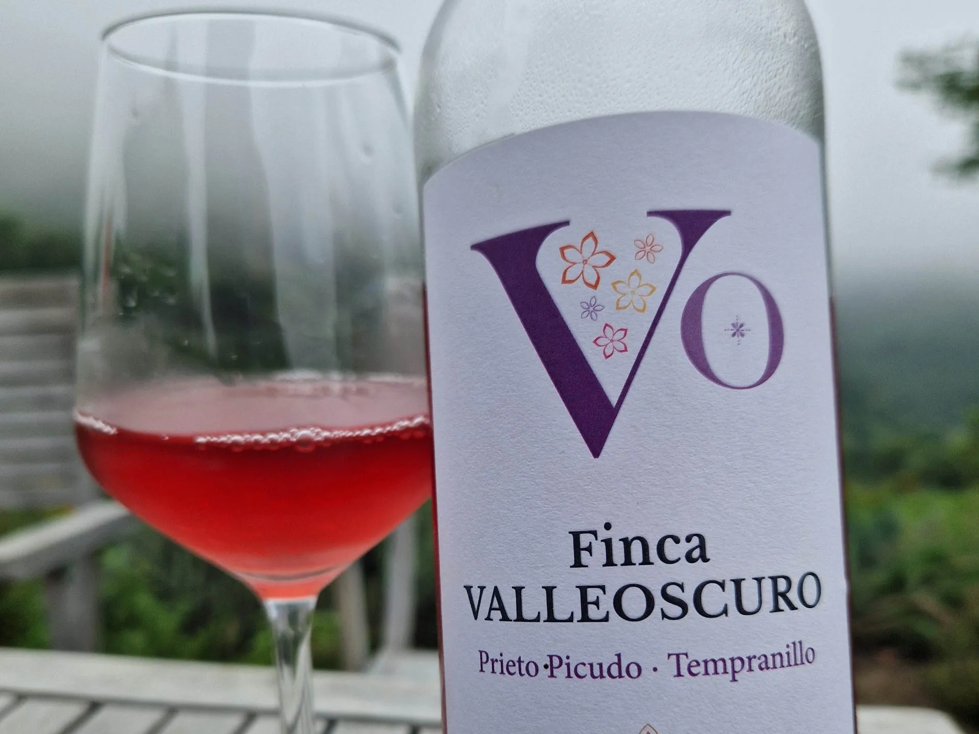 Eine Flasche Roséwein und im Hintergrund ein Glas