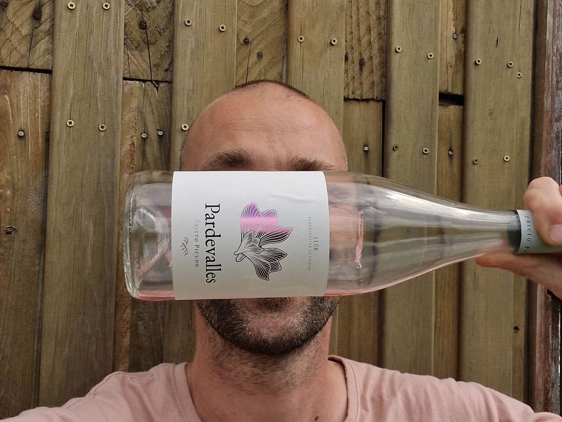 Mann hält sich Weinflasche vor das Gesicht