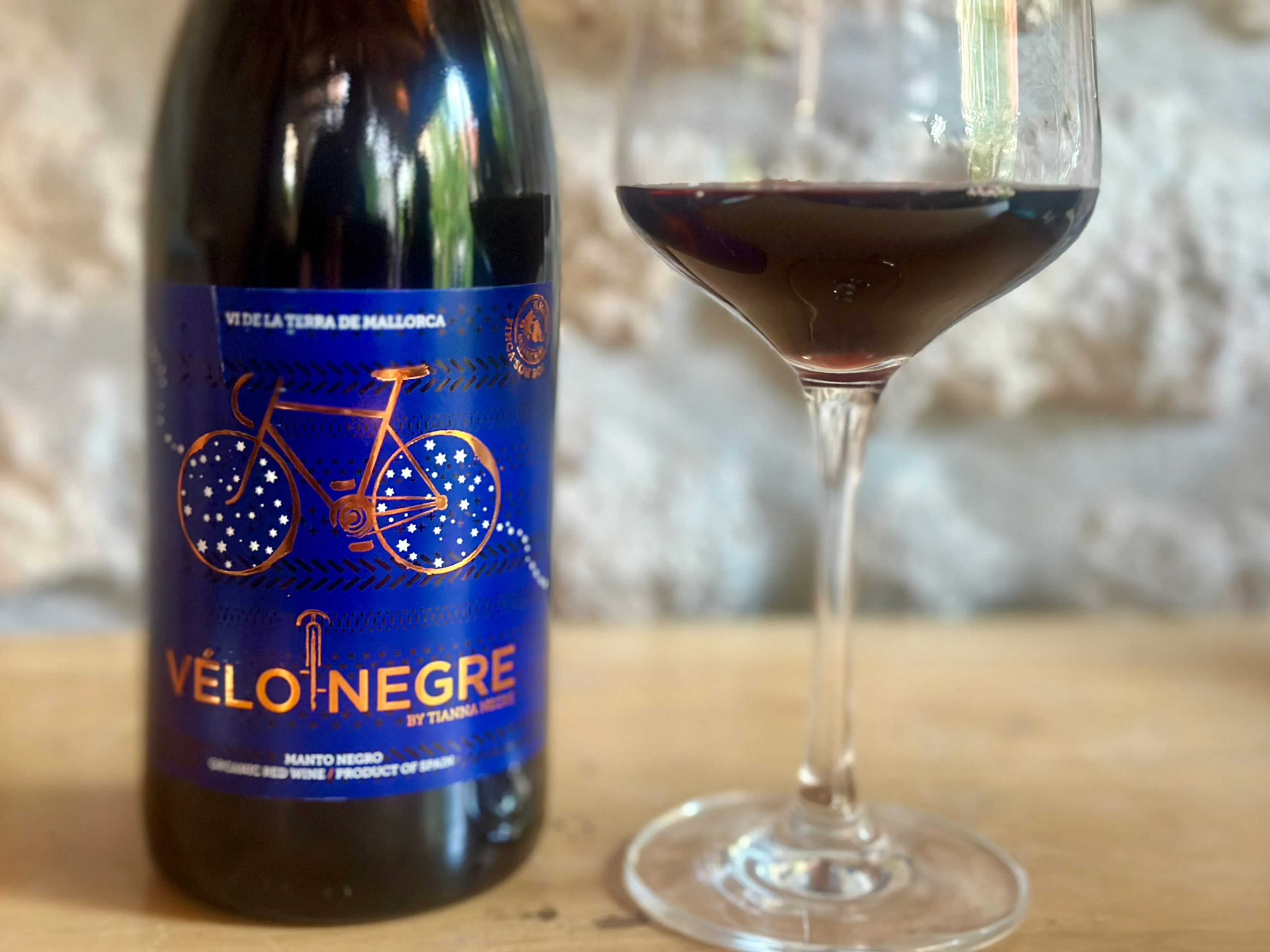 Rotweinflasche mit Glas mit blauem Etikett mit Fahrrad