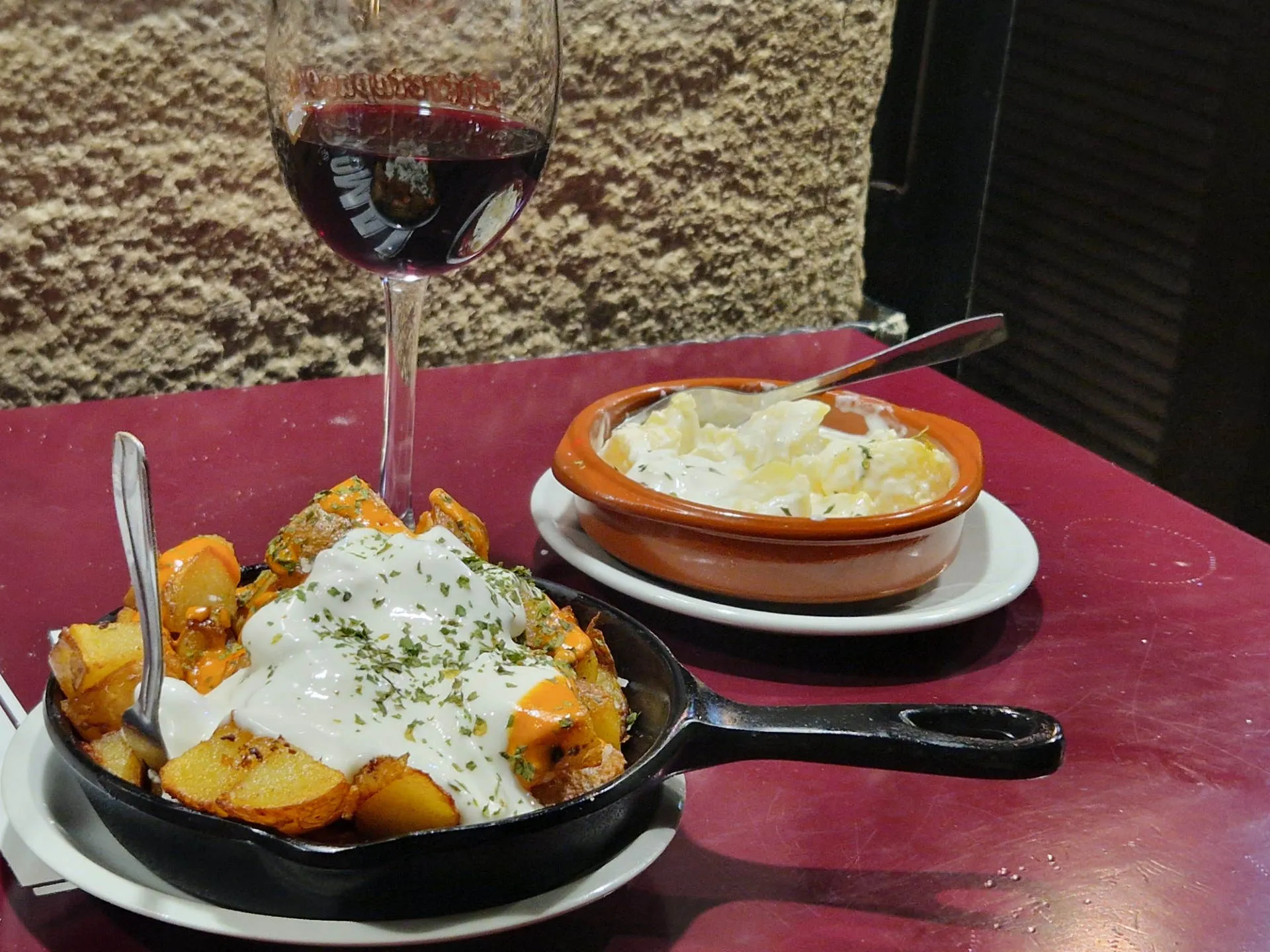 Zwei Schüsseln mit Patatas Bravas und Wein