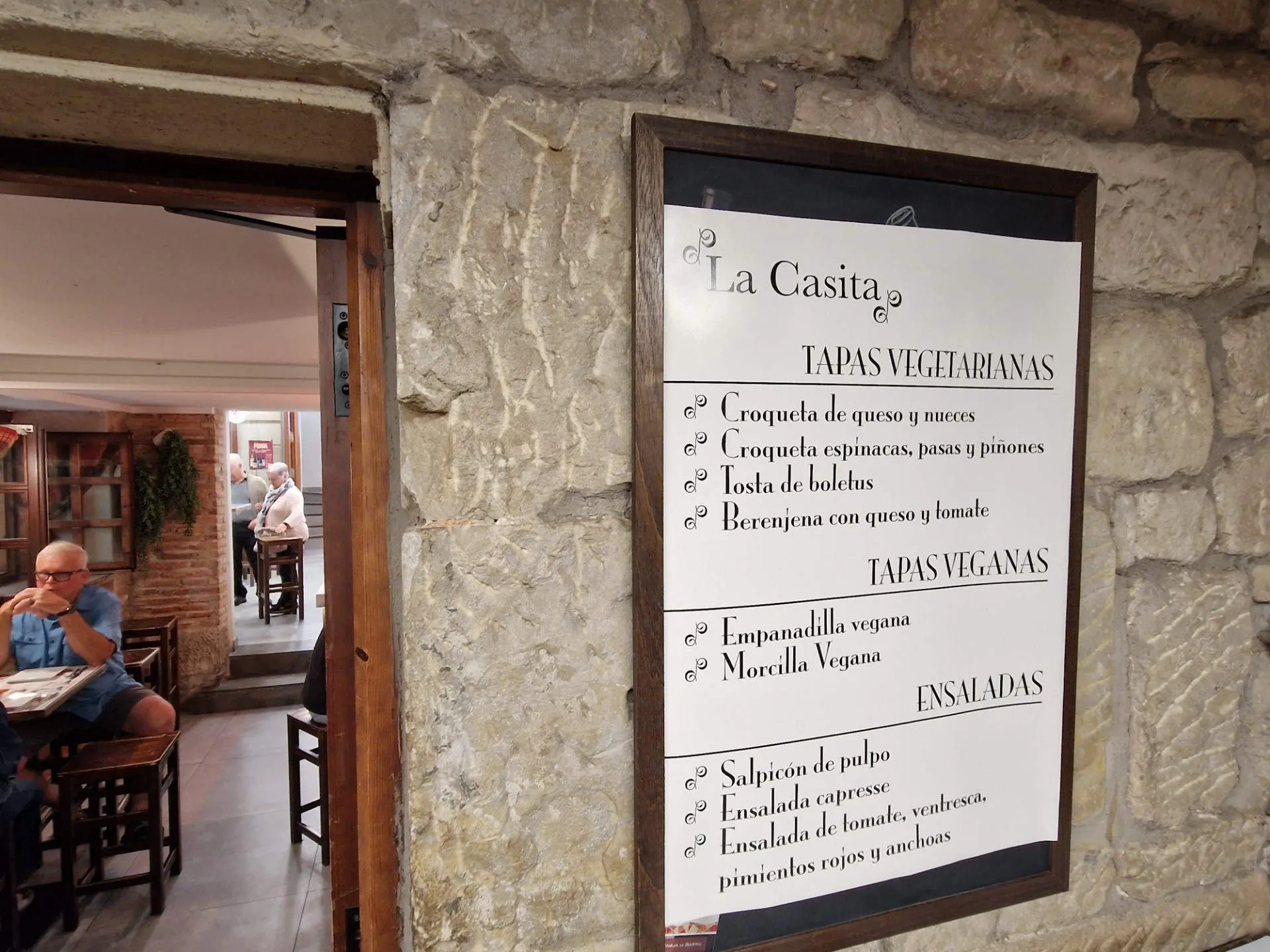 Ein Schild einer Bar mit verschiedenen vegetarischen Gerichten.