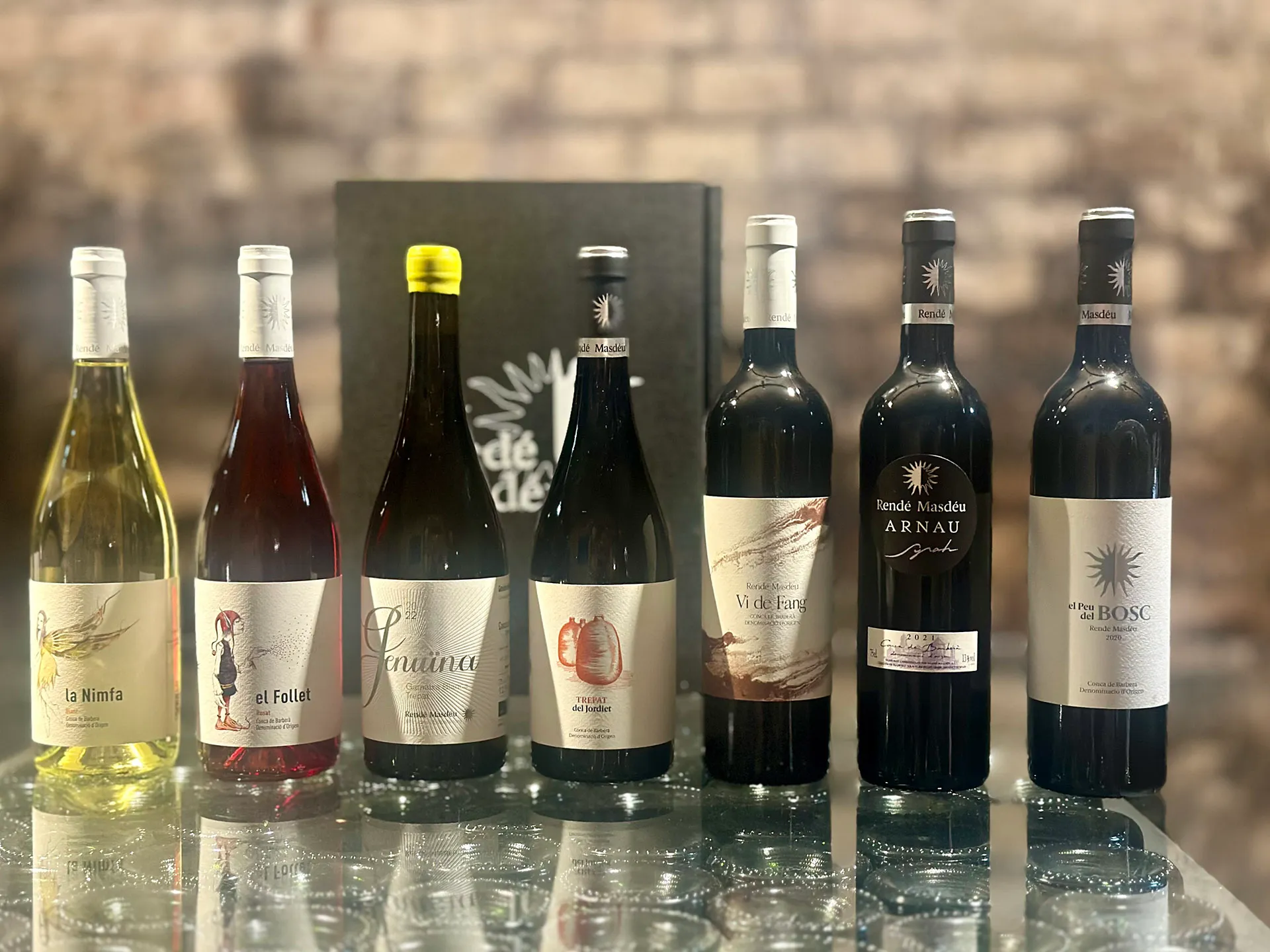 viele Weinflaschen in einer Reihe auf einem Glastisch