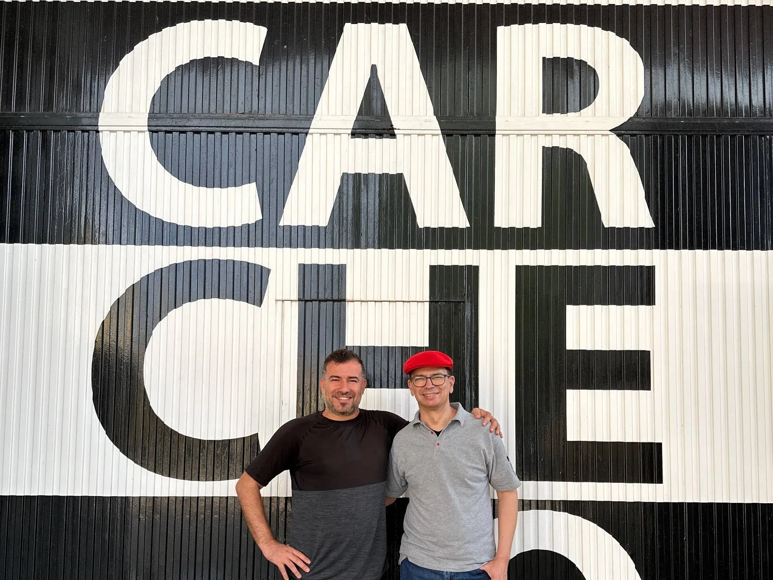 Zwei Personen vor bemalten Containern