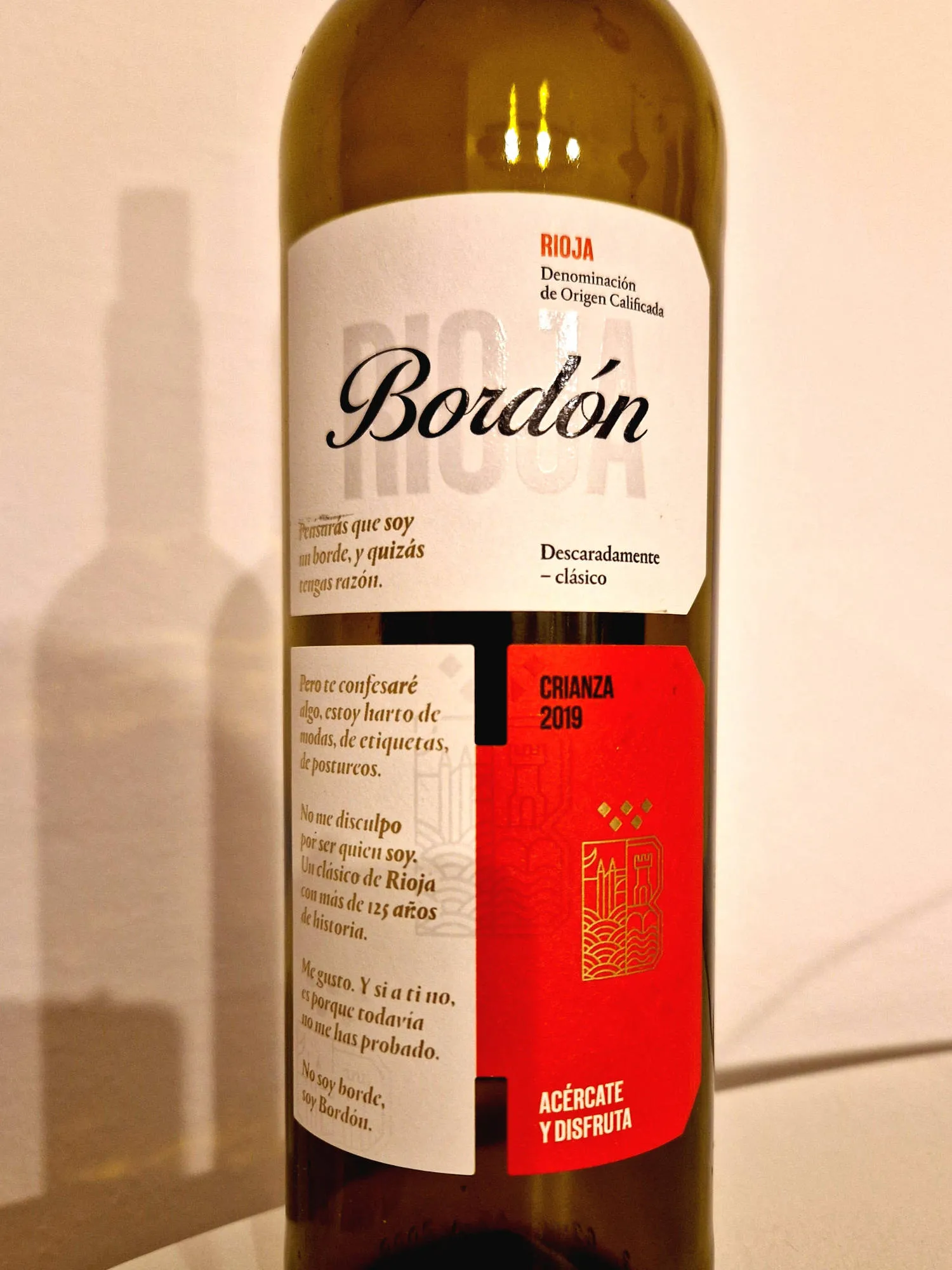 Eine Flasche Rotwein vor einer weißen Wand