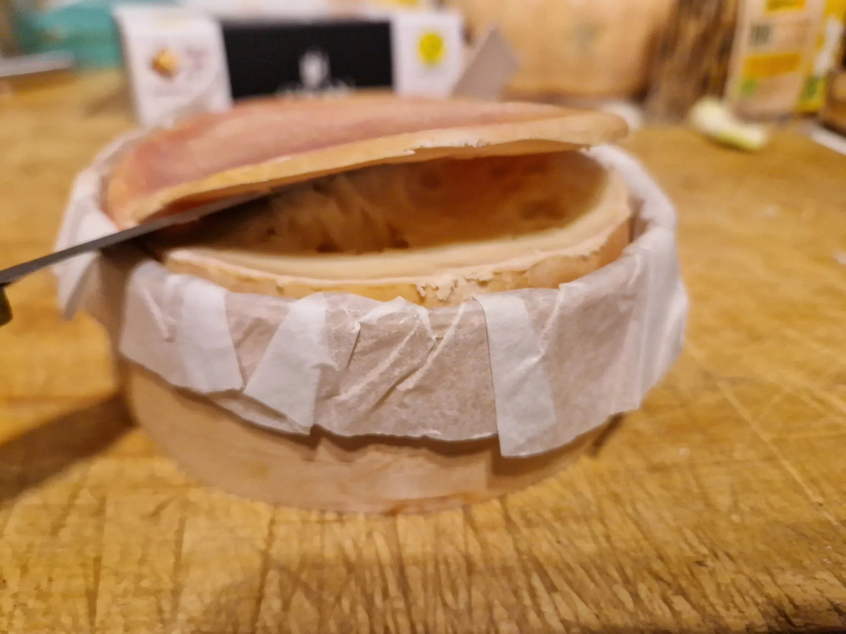 Der Deckel einer Torta del Casar wird abgeschnitten.