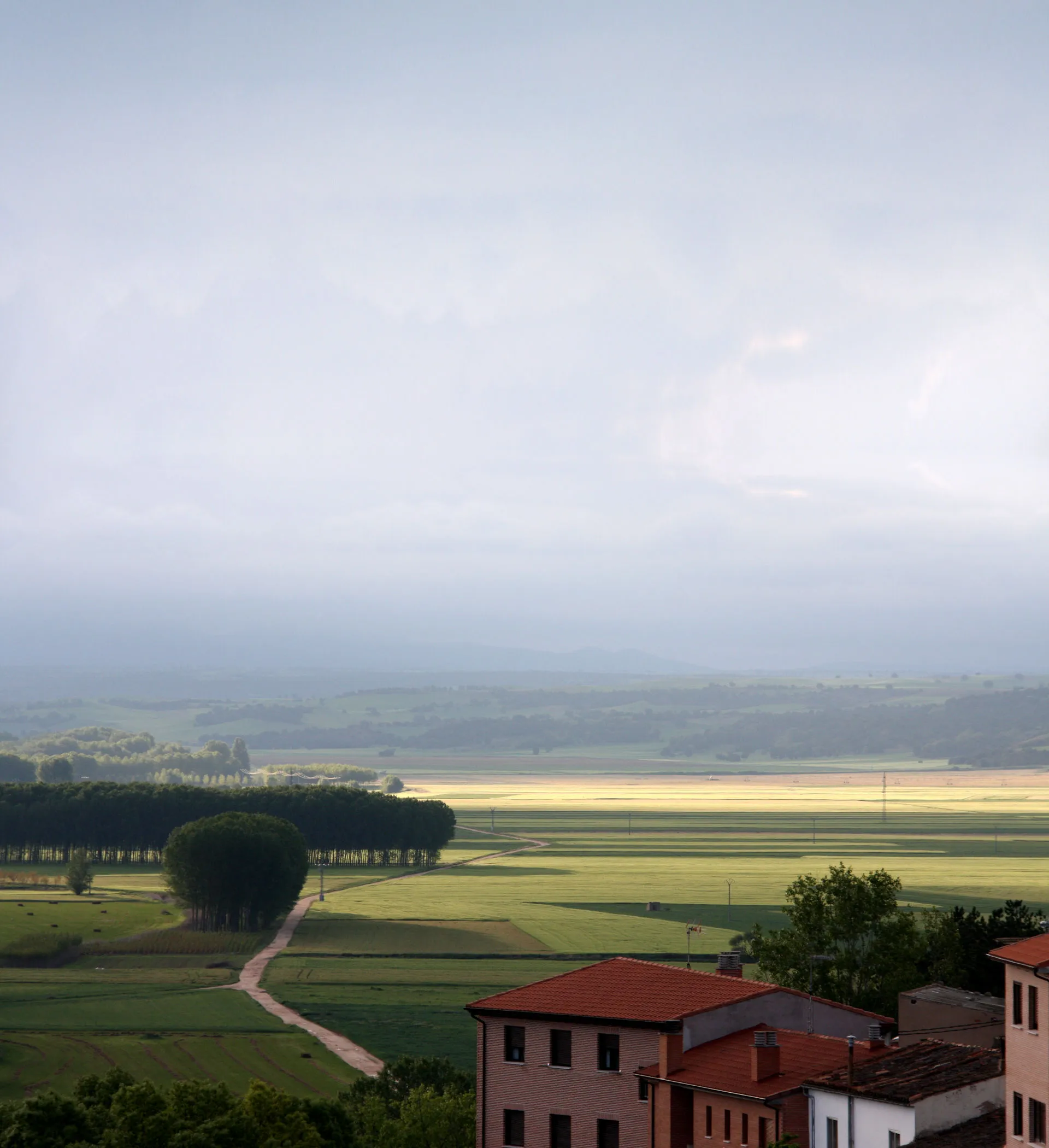 Landschaft in Kastilien und León mit kleinem Dorf im Vordergrund und schönem Lichteinfall der Sonne